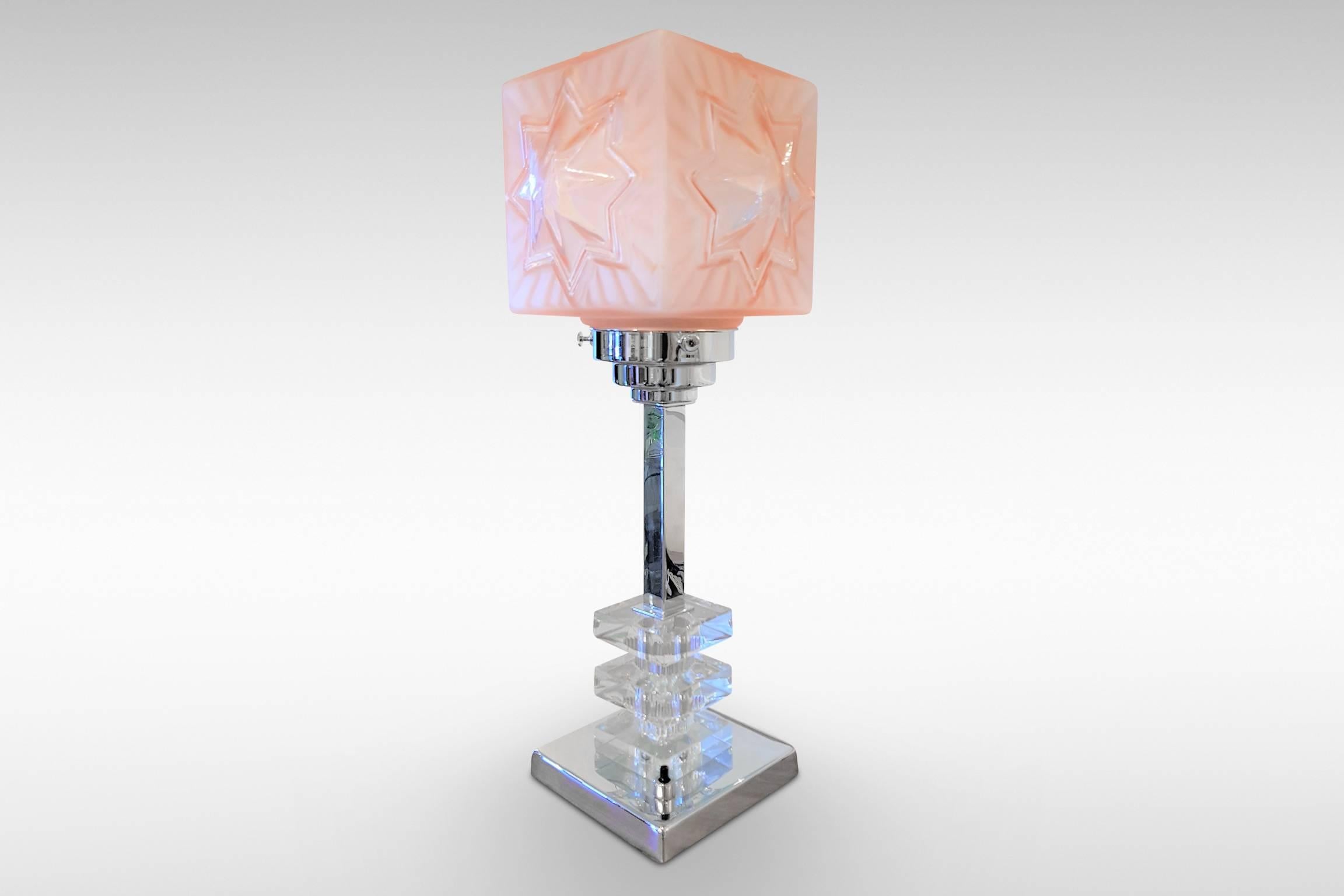 A geometric style Art Deco original chrome table lamp with tiered glass blocks to the column and a pink 'starburst' cubic shade.