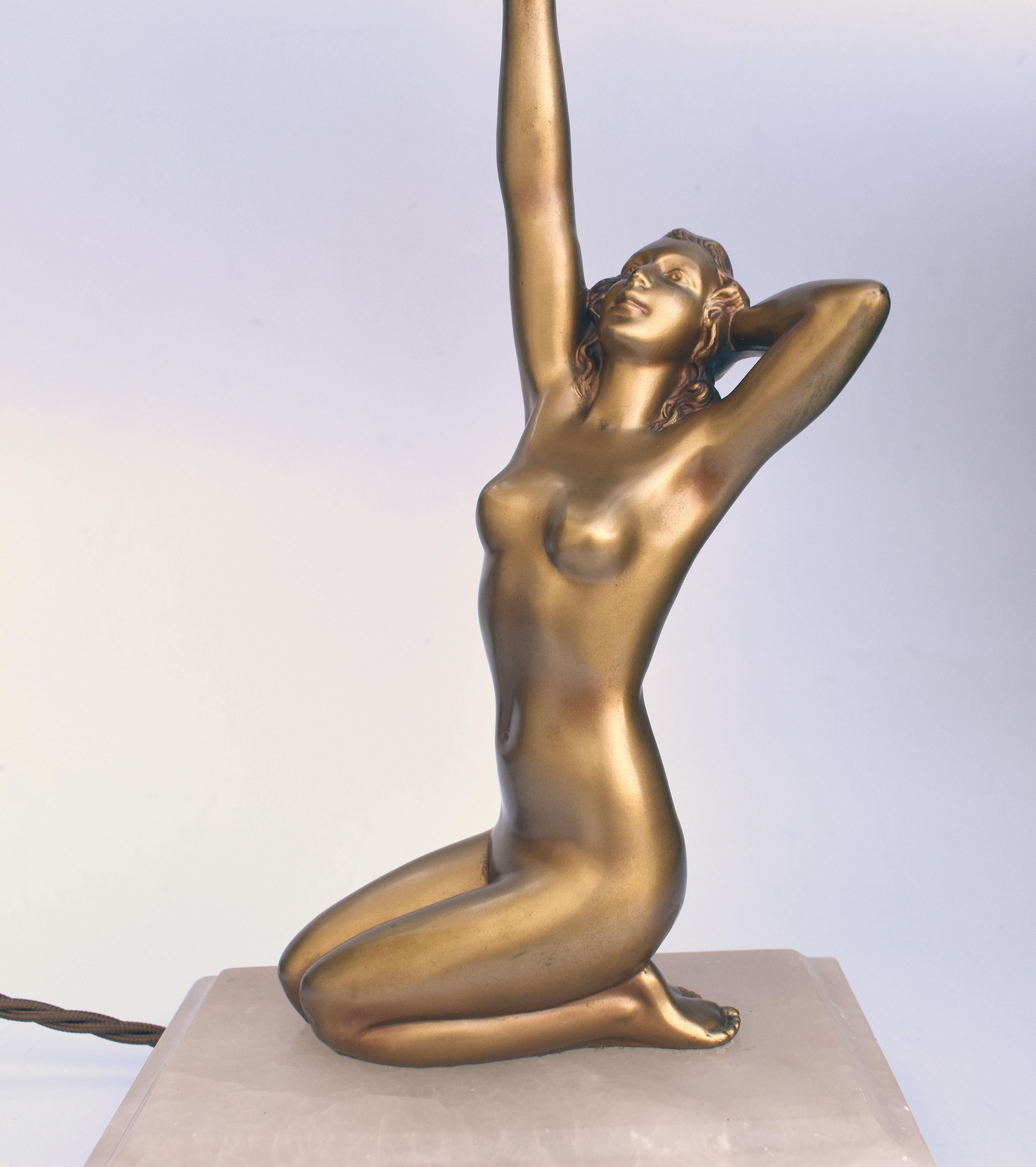 An impressive 38 cm tall this original 1930's Art Deco cold painted spelter table lamp features a nude female holding aloft a milk white glass globe shade. Kneeling on an alabaster base she is in beautiful condition with hardly any visible wear to