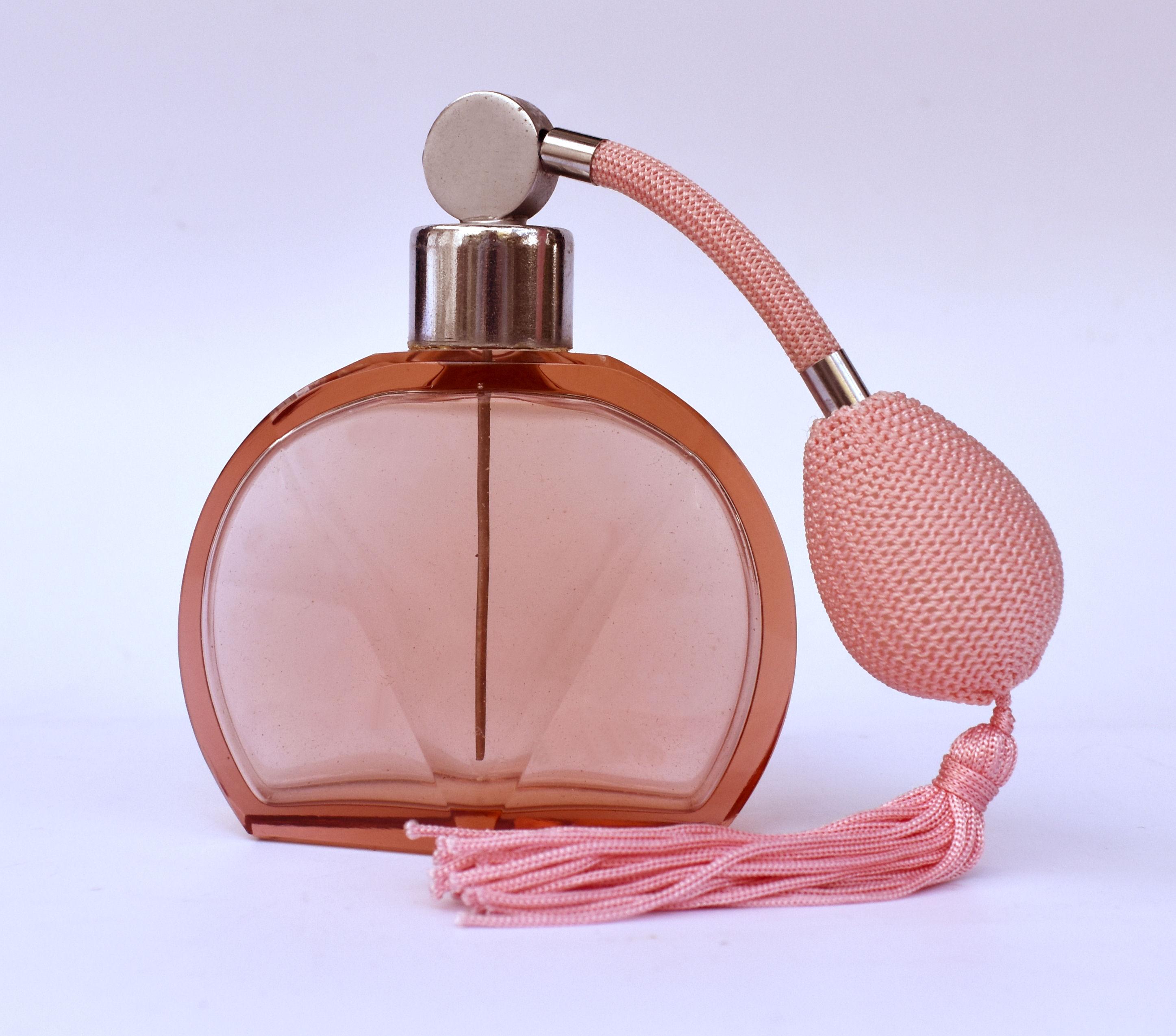 This large perfume atomiser is an absolute delight. 1930's authentic Art Deco with a very desirable overall design in peachy color. Glass is in excellent condition with no damage or flaws to report. The tassel and puffer are also in good condition
