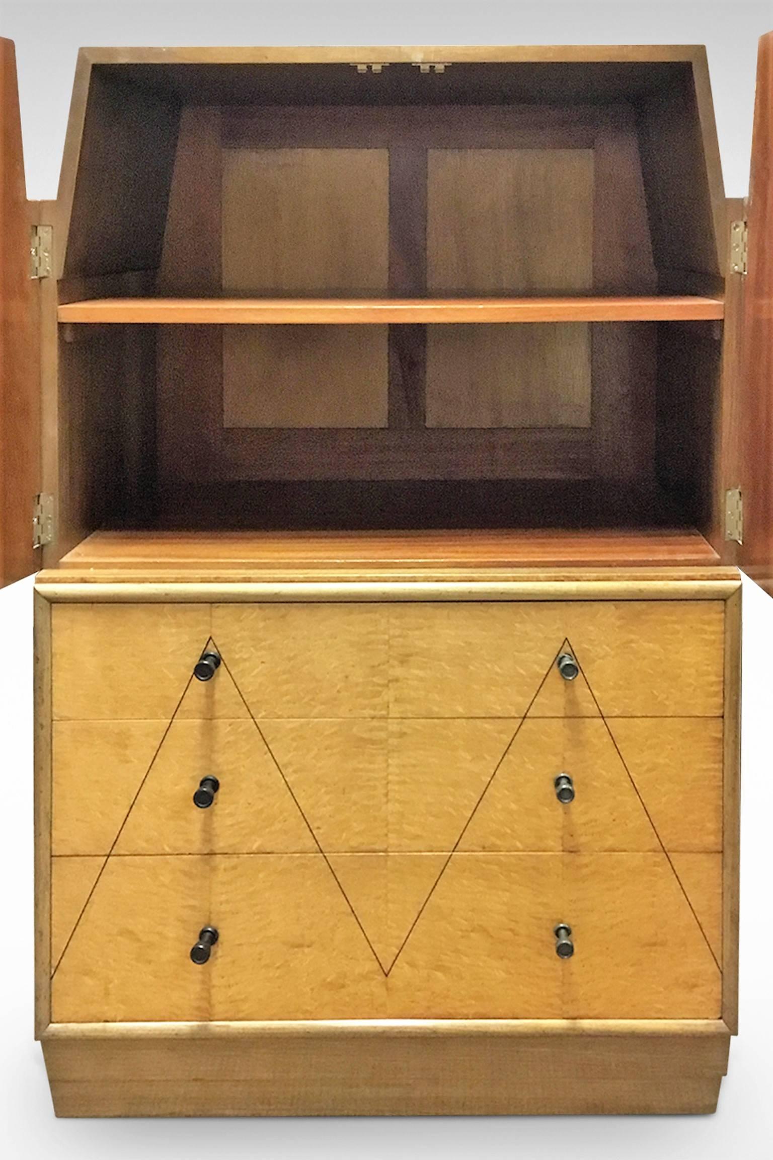 A stunning and original Art Deco cabinet in the skyscraper style with a chiseled stepped outline to the cupboard sides and plinth.
It offers three drawers with a cupboard over in Hungarian Ash veneers. The top and sides are in walnut,
circa