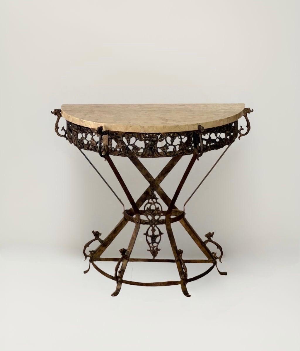 1920s Art Deco bronze and iron petite demi-lune console or side table with cream colored marble top in the manner of Oscar Bruno Bach. Uniquely designed iron frame base with bronze frieze featuring openwork of grapevines and Bach form theatrical