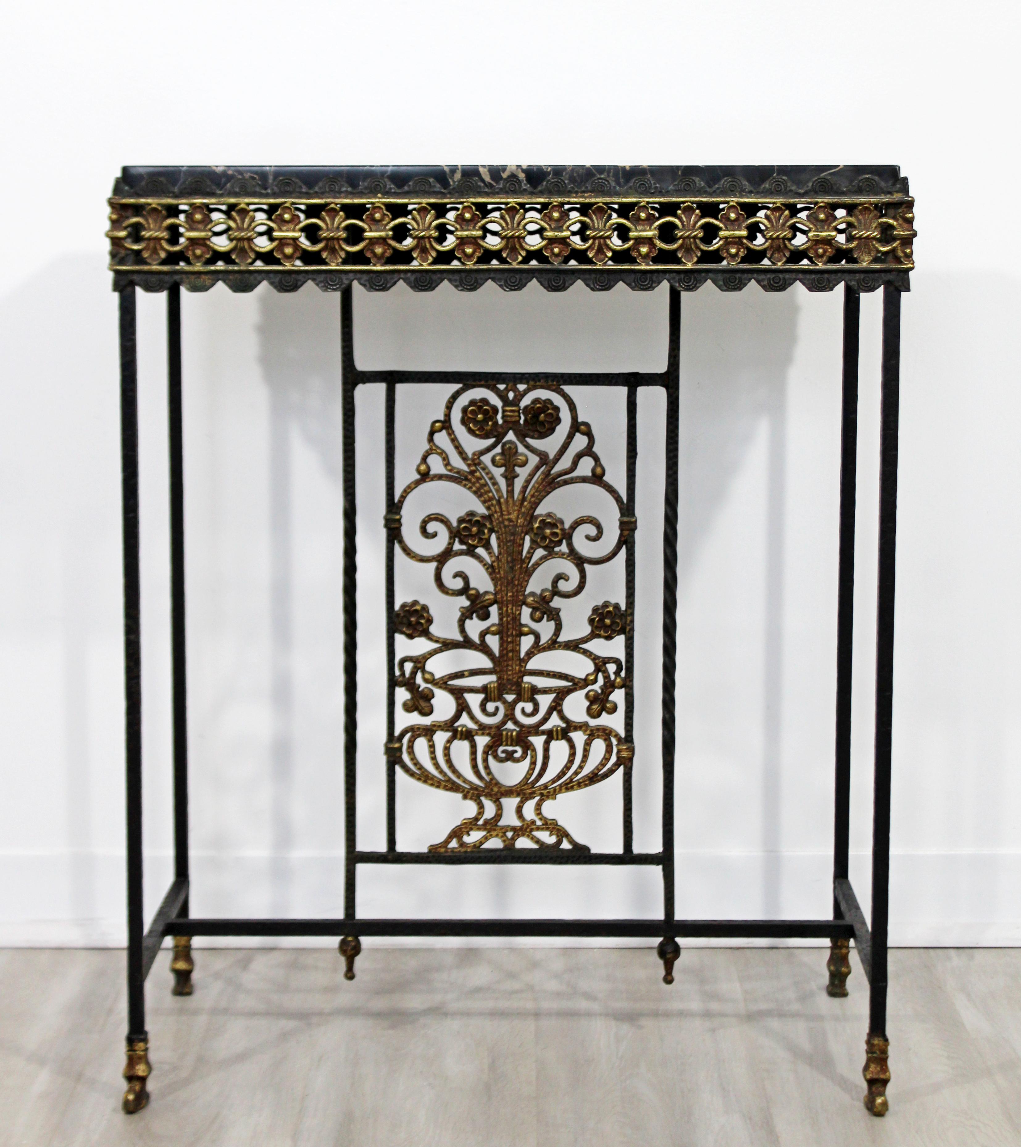 For your consideration is a magnificent console table, with a black marble top on a beautifully designed, scalloped edge, wrought iron and brass base, by Oscar Bach, circa 1930s. In excellent patinated antique condition. The dimensions are 24.5