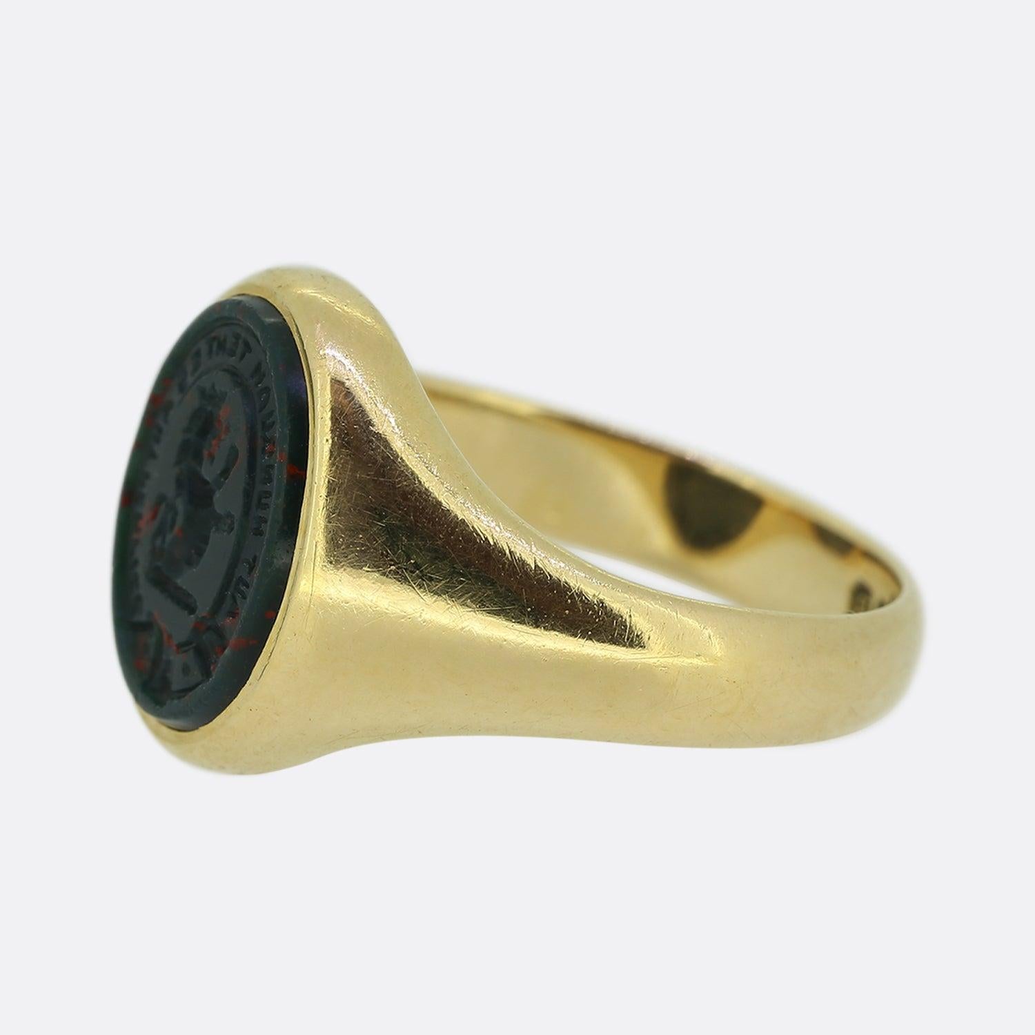 This is a wonderful 18ct yellow gold signet ring that dates back to the Art Deco era. The face of the ring features an engraved bloodstone with a rampant lion in the centre. The lion is surrounded by the Latin words 'Aut nunquam tentes aut ferfice'