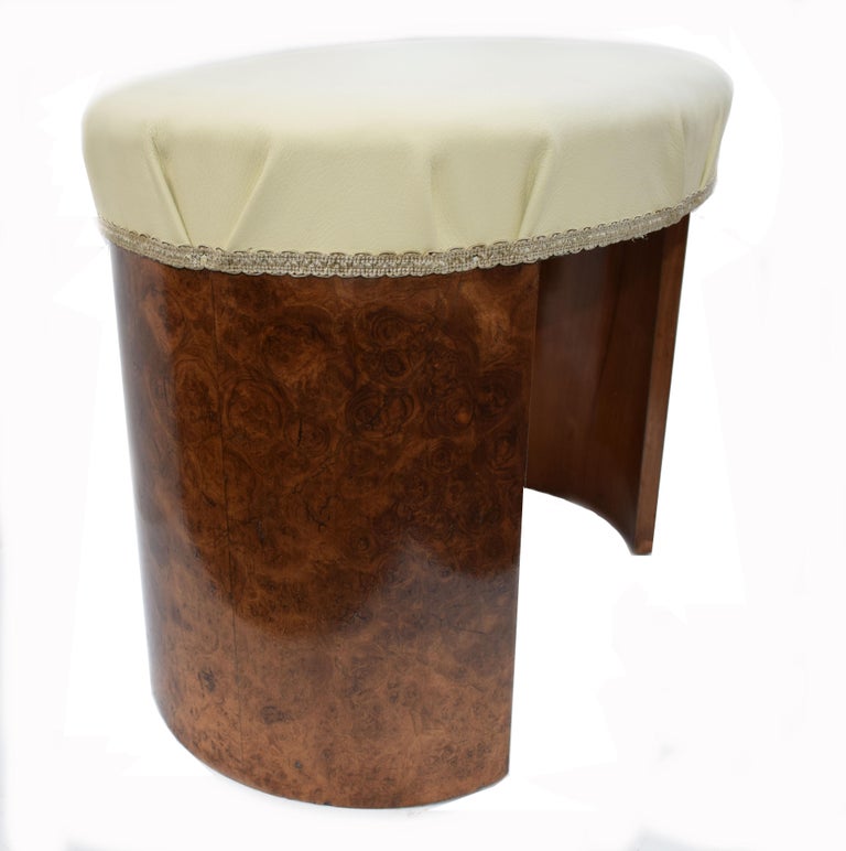 Very attractive, 1930s Art Deco heavily figured walnut veneered stool. Although originally purposed as a bedroom stool there is nothing to stop you using this as a regular footstool. It's recently been recovered in a soft cream leather and shows