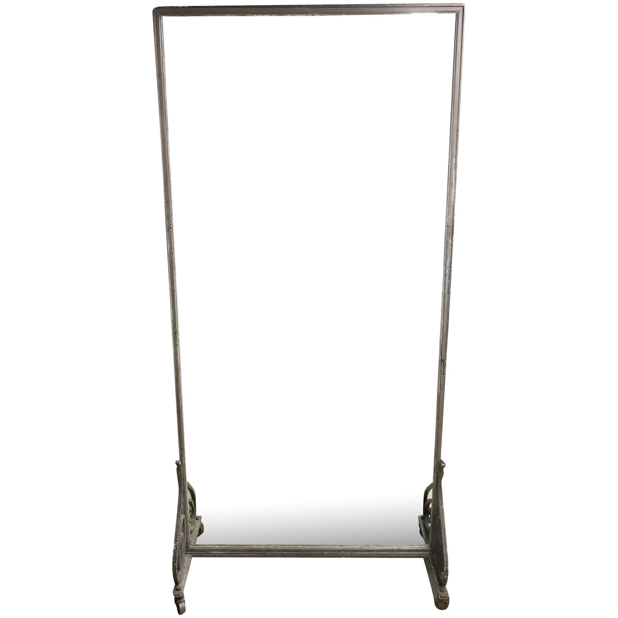 A great Art Deco oversized rectangular dressing mirror in a metal molded frame with metal back, supported on a wrought iron stylized scrolled base support frame on iron casters. The mirror probably dates to the early 20th century and was probably