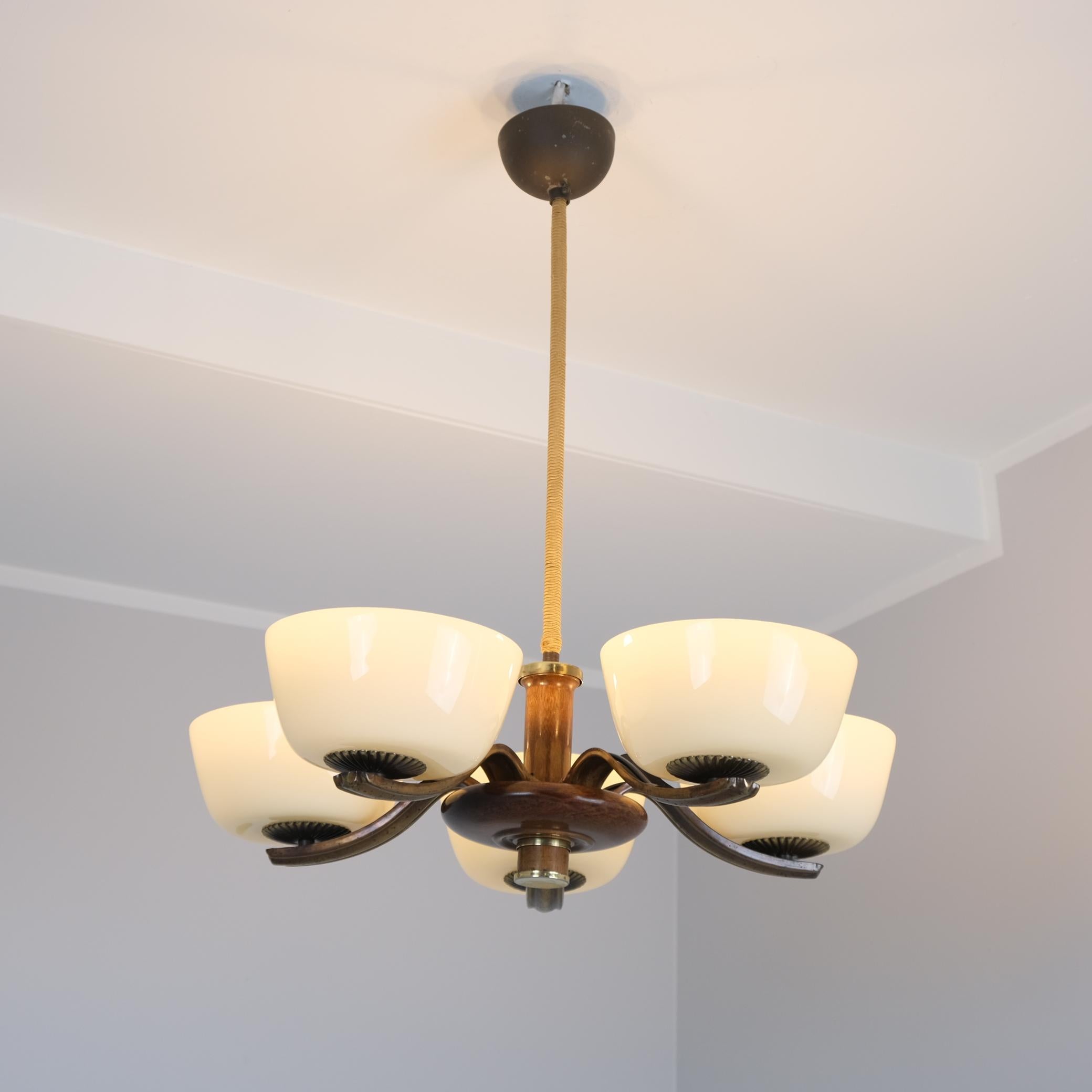 Un bel et rare exemple de lampes Paavo Tynell des années 1930. Une merveilleuse pièce en bouleau teinté foncé, laiton poli et oxydé avec des abat-jours en verre soufflé. La lampe est dans son état d'origine. Les abat-jours en verre soufflé sont d'un