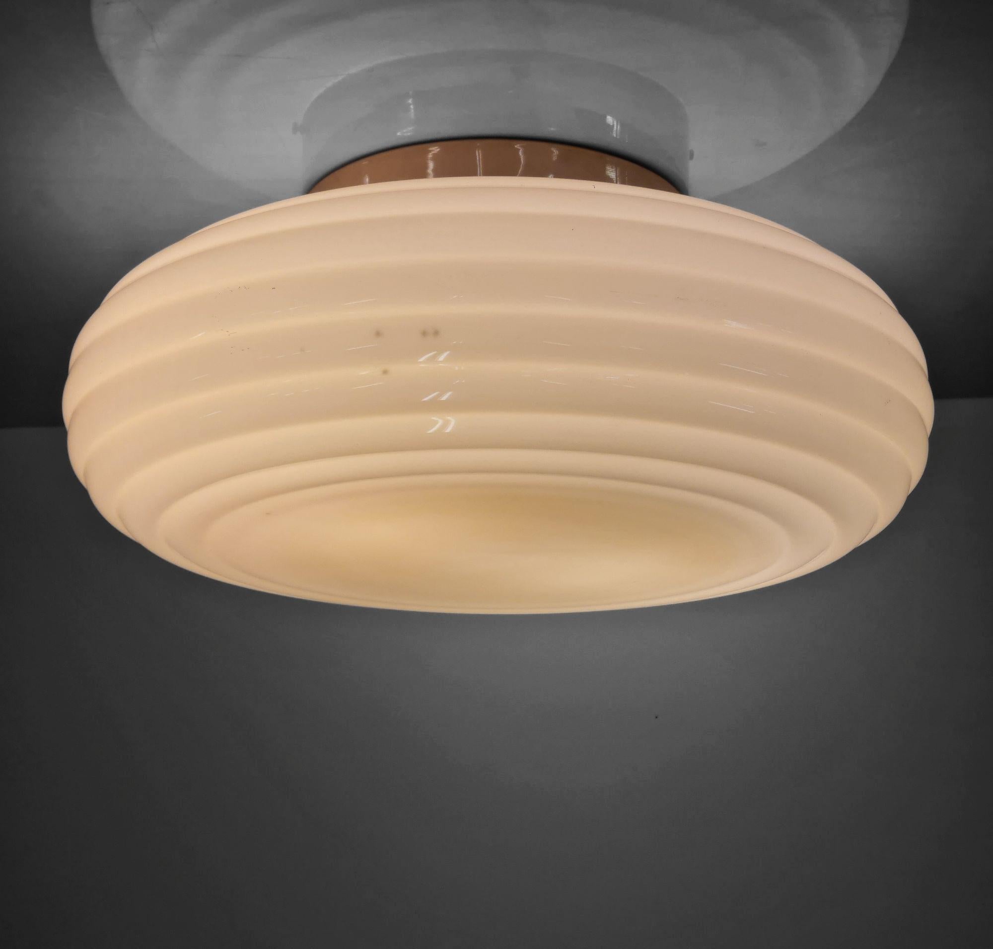 Un'elegante lampada da soffitto minimalista in stile art déco, realizzata da Paavo Tynell e prodotta da Taito negli anni Trenta. Questa lampada, insieme ad altre presenti nel nostro elenco, proviene dall'edificio Ilveslinna di Jämsänkoski ed è stata