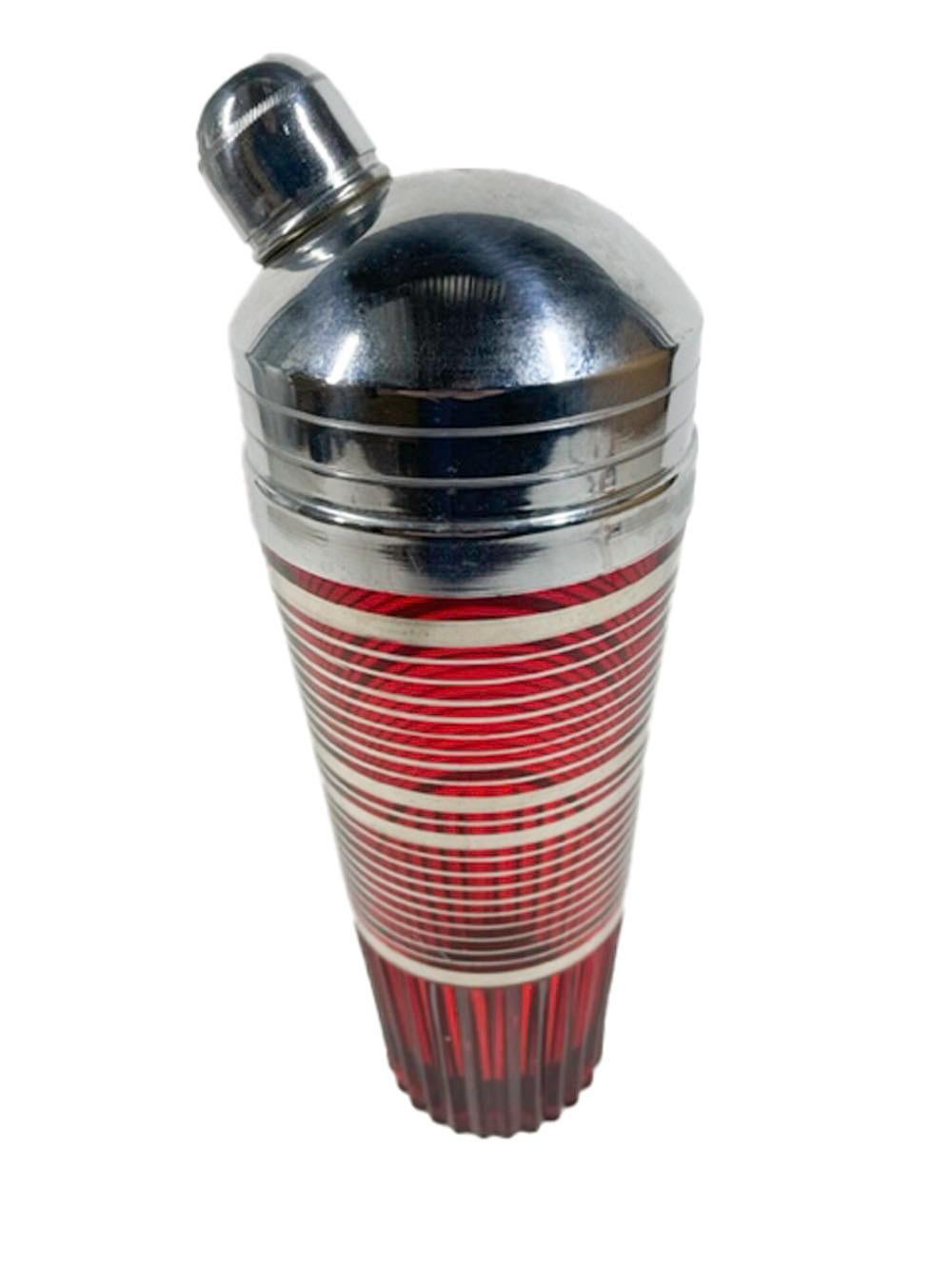 Art Deco period cocktail shaker in the Glades pattern by Paden City Glass. In ruby red glass with silver bands above a rib molded base and with a high-domed chrome lid with angled spout.