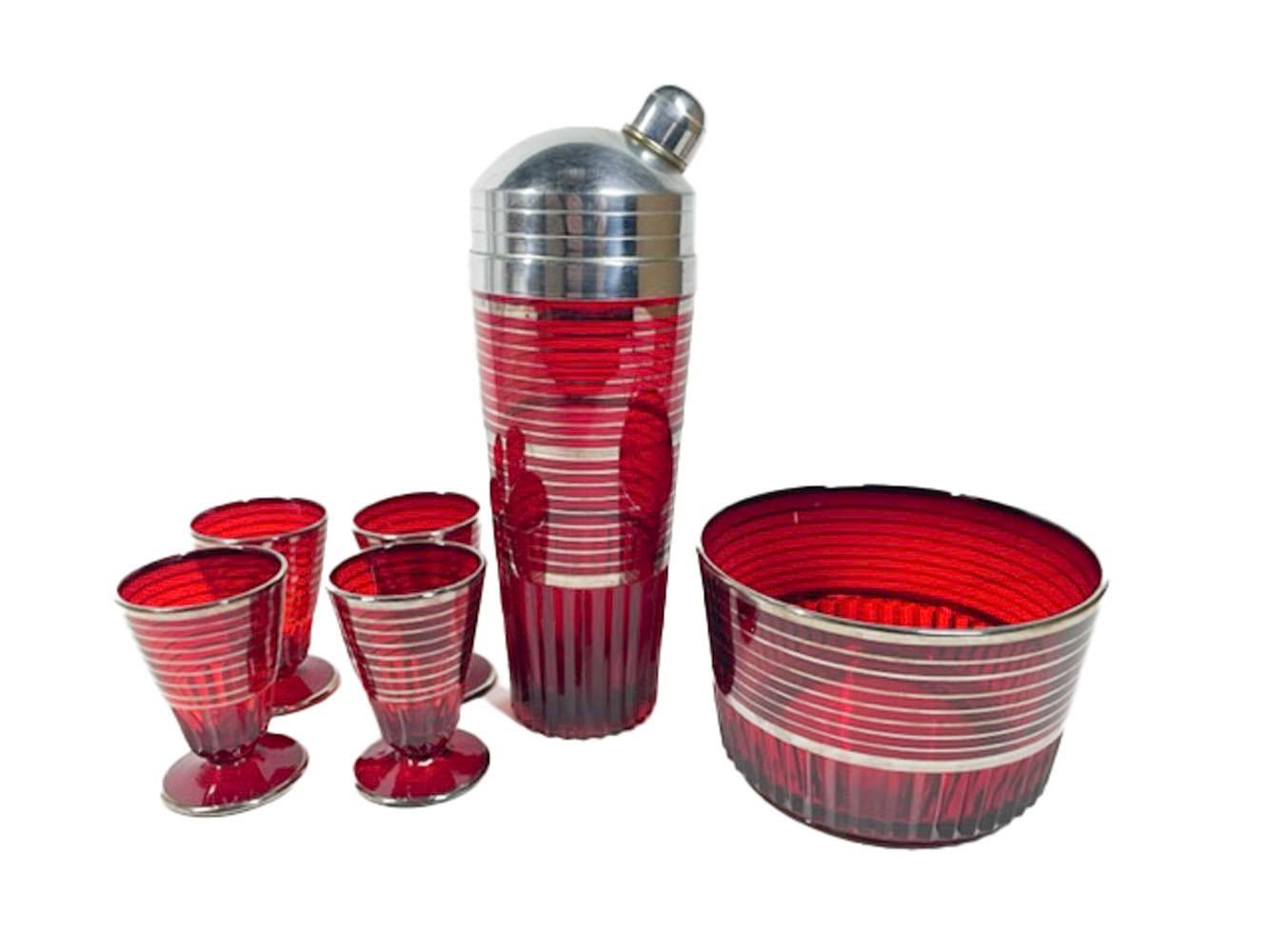Art Deco cocktail set in the Glades pattern by Paden City Glass. Ruby glass with silver rings above a rib molded lower section. The set consisting of a Shaker with domed chrome lid, ice bowl and four conical cocktail glasses on a circular