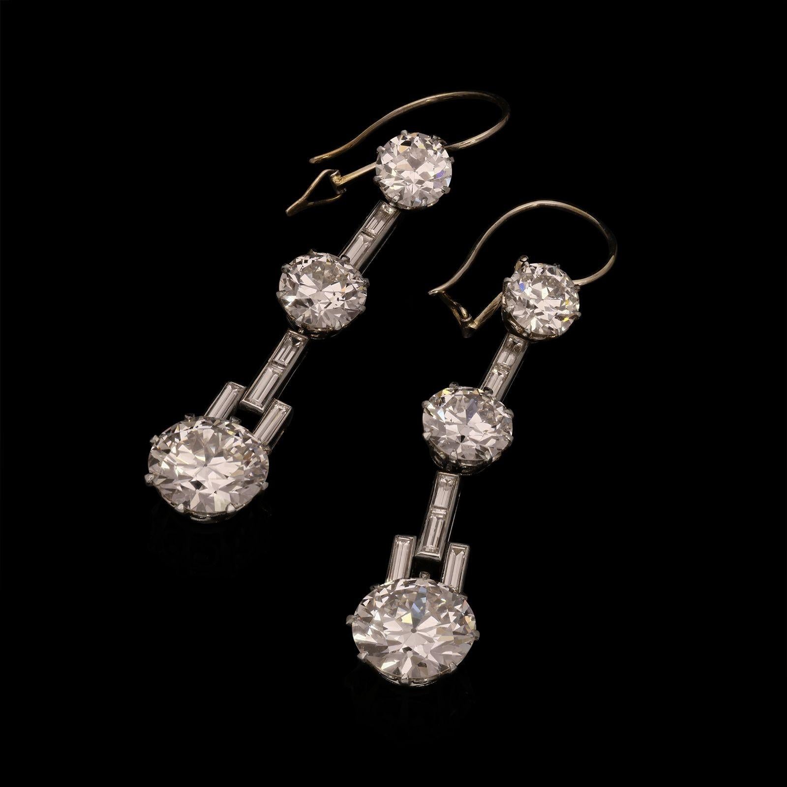 Une superbe paire de boucles d'oreilles en diamant Art Déco vers 1935, chacune conçue comme une longue goutte de trois diamants européens gradués de taille brillante pesant un total combiné de 7,67cts, intercalés avec des diamants baguettes dans une