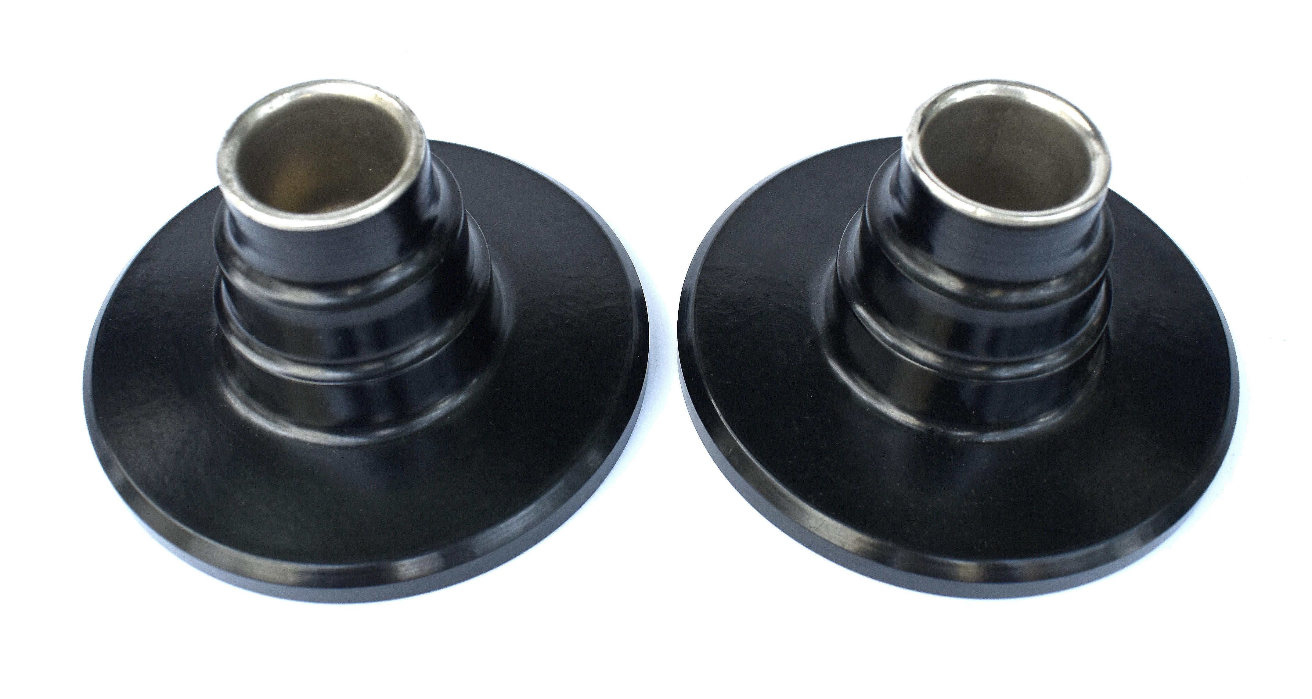 Super stylish matching pair of black bakelite candlesticks dating from the 1930's and English in origin. Excellent condition, no burn marks, chips or discolouration. Both have their original metal weighted bases and metal liner inside to protect the