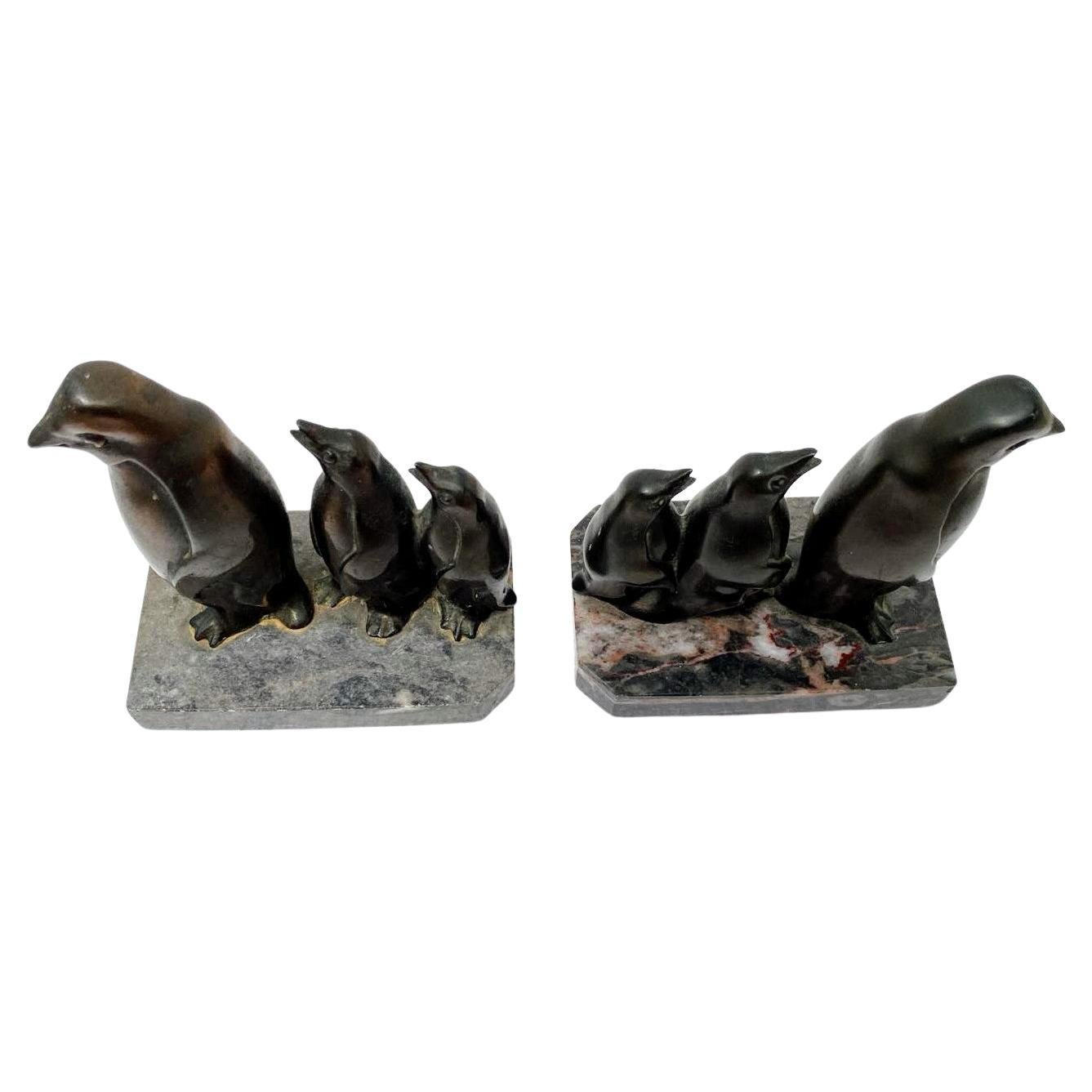 Coppia di fermalibri Art Deco molto elegante e rara. Sono un'ottima scoperta e in condizioni eccezionali. Provenienti dalla Francia e risalenti agli anni '30, entrambi poggiano su basi di marmo e raffigurano una famiglia stilizzata di tre pinguini