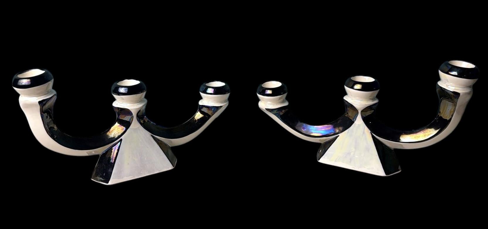 Elegante coppia di portacandele in ceramica francese, impreziosita da un raffinato smalto a lustro con riflessi iridescenti di madreperla che passano dal bianco perla al blu intenso a seconda della luce. Questa finitura sofisticata è caratteristica