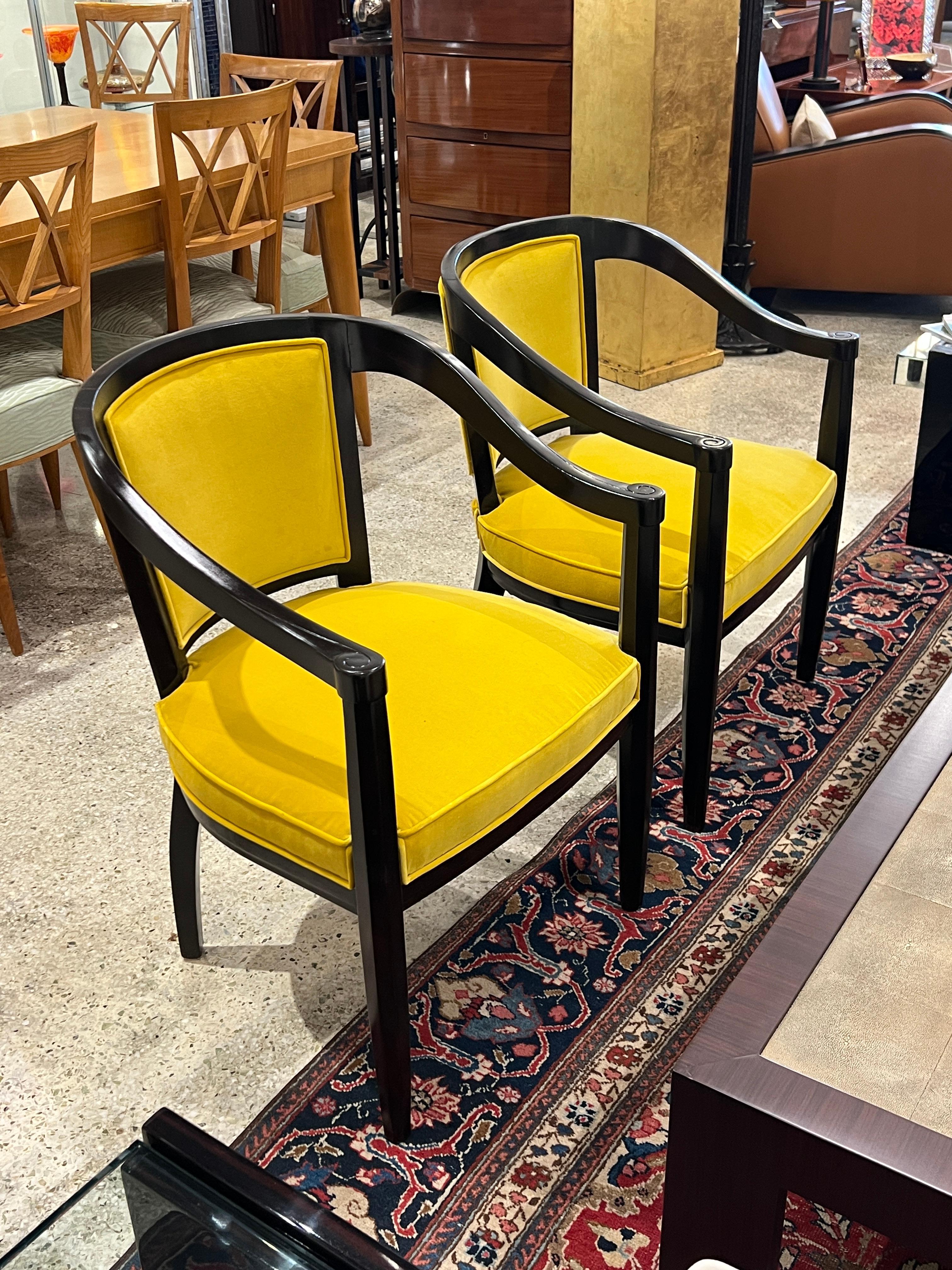 Dieses Paar Art-Déco-Sessel von René Prou verkörpert die raffinierte, geschwungene Ästhetik und den eleganten Sinn für Proportionen des Designers. Sie sind mit dramatisch schwarz lackierten Holzrahmen und leuchtend gelben Polstern ausgestattet und