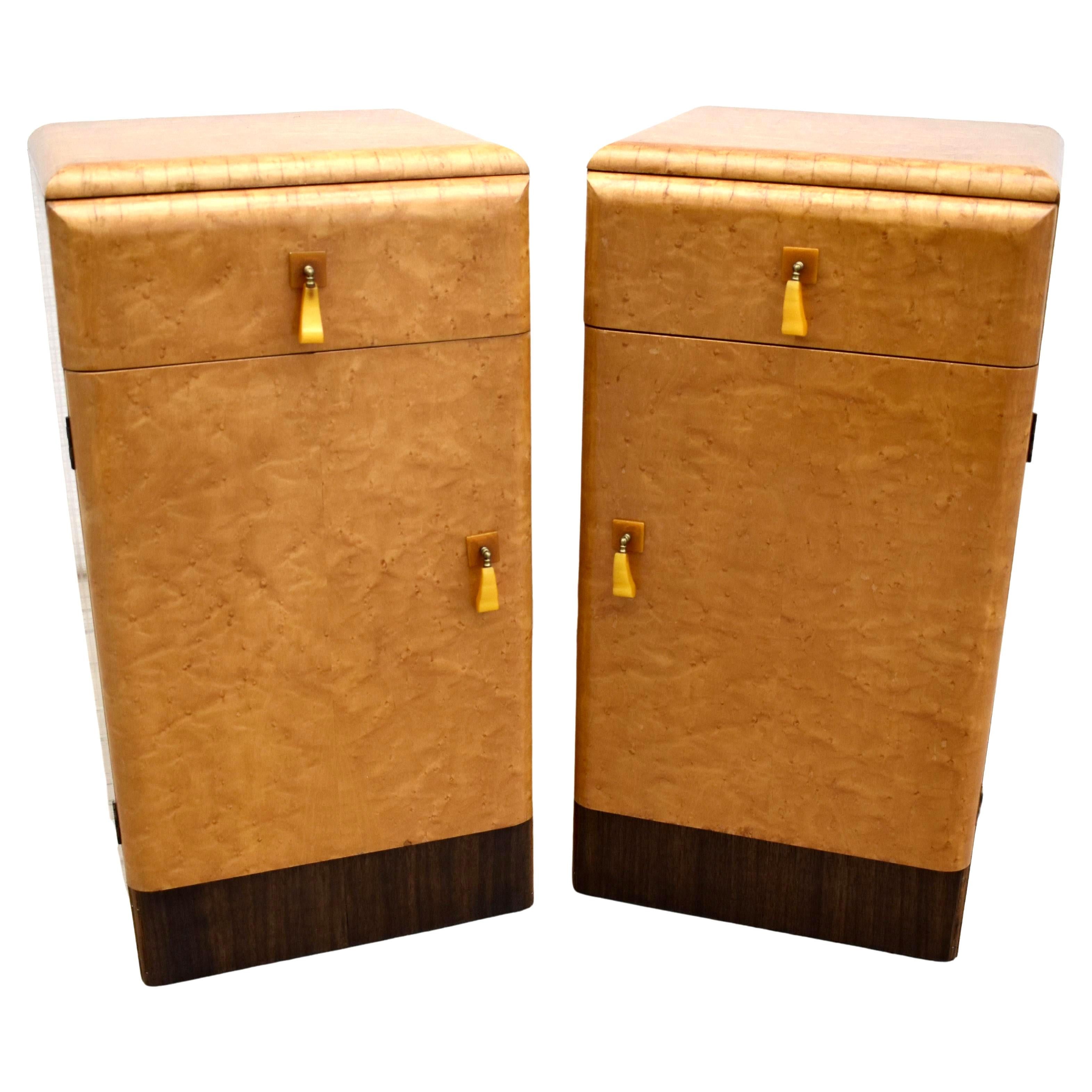 Fabulous pair of matching 1930s Art Deco bedside cabinet tables in a lovely true blonde bird's-eye maple on a walnut plinth. These cabinets originate from England and feature a single door which opens to two internal open shelves. Single upper