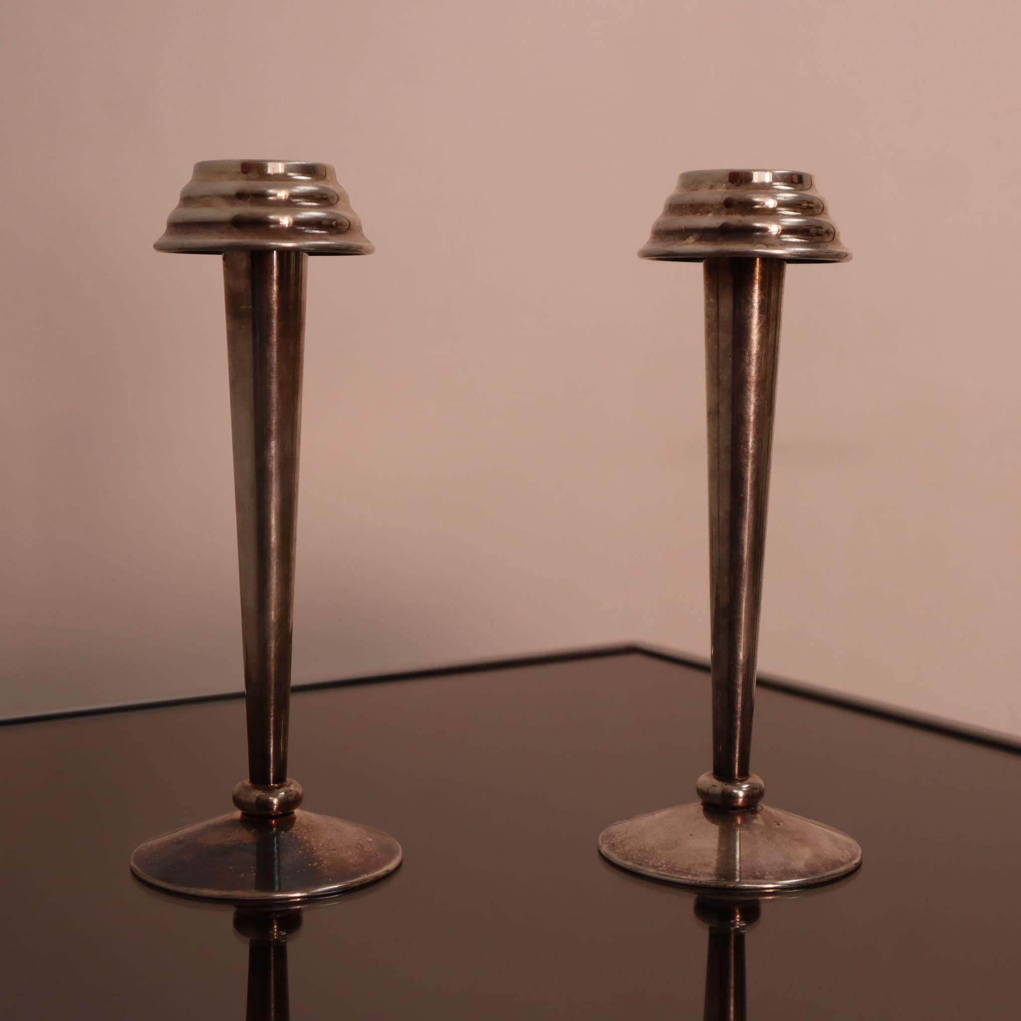 Coppia di portacandele in ottone nichelato, Art Déco, Italia, anni '30

Questa raffinata coppia di portacandele Art Déco, realizzata in ottone nichelato, incarna la raffinata eleganza e la precisione geometrica degli anni Trenta. La patina originale