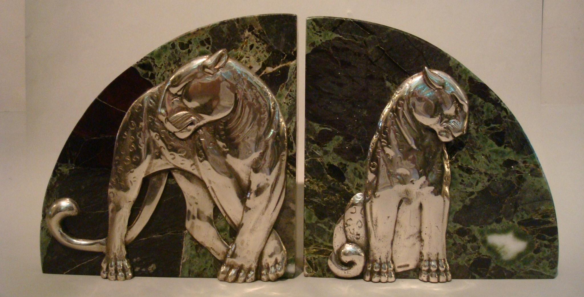 Art Deco pair of panther bookends. Silvered bronze and marble. Made in France, 1920s. Both stamped France. Heavy green and white marble bookends.
In the style of Paul Jouve.


               