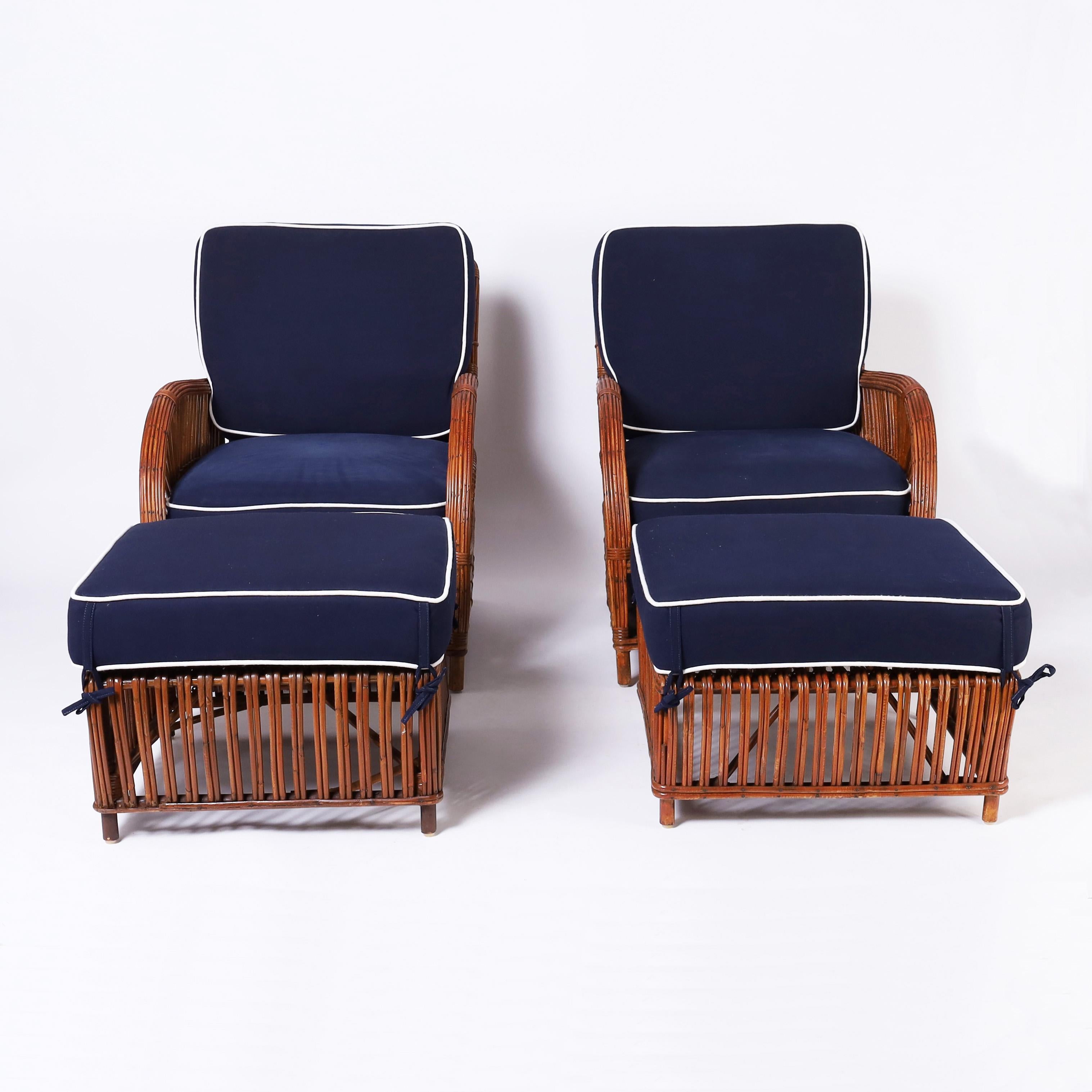 Like something out of a 1930s movie, a pair of rattan art deco lounge chairs having a streamline form with matching ottomans all dressed in blue and white upholstery. 

Chairs measure H: 31 W: 27 D: 37 

Seat height with cushion 16