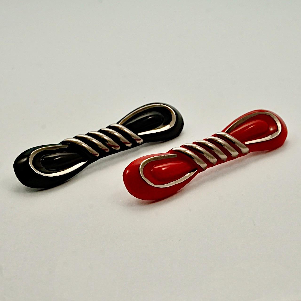 Wonderful Art Deco pair of red and black glass bow brooches, with silver tone highlights. Measuring length 6.6 cm / 2.5 inches by width 1.4 cm / .55 inch.

These are very stylish and unusual brooches in red and black glass, from the 1930s. 