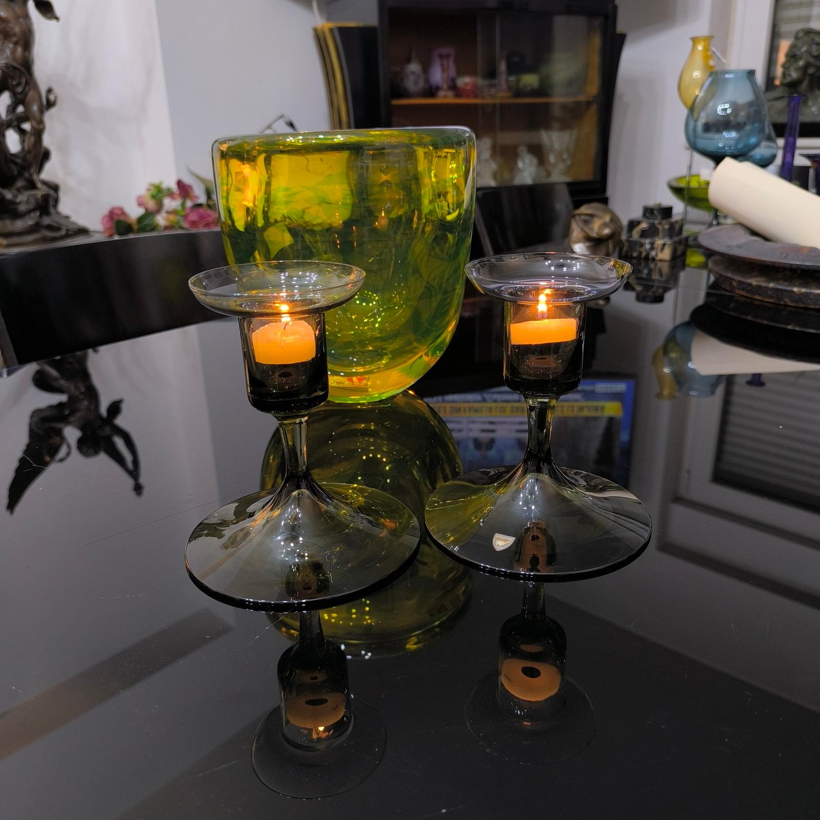 Una coppia di candele Orrefors, mai viste in questa forma. Etichetta originale del produttore, risalente ai primi anni '20. Questa delicata coppia di candelabri o portacandele in vetro soffiato verde fumo è molto bella e prodotta da Orrefors,