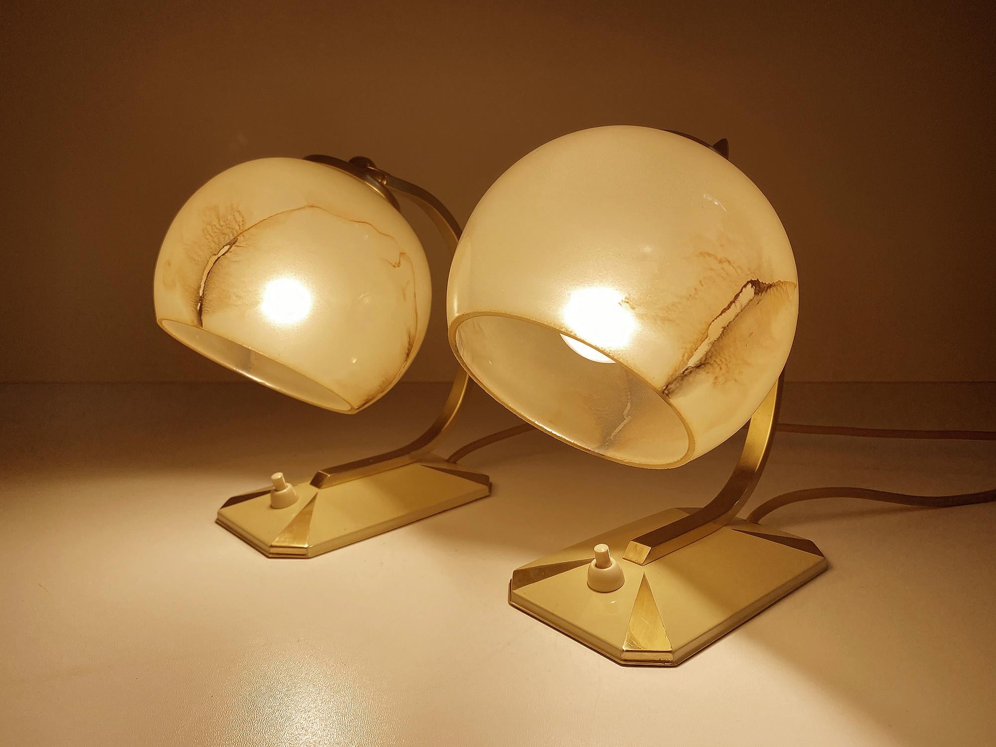 Gorgeous pair of Art Deco table lamps, featuring an octagonal base with a cream enamel and brass pattern base, cradle shaped stems and caps, stunning marbleized opaline overlay glass shades, cream white with brownish beige highlights. The shade’s