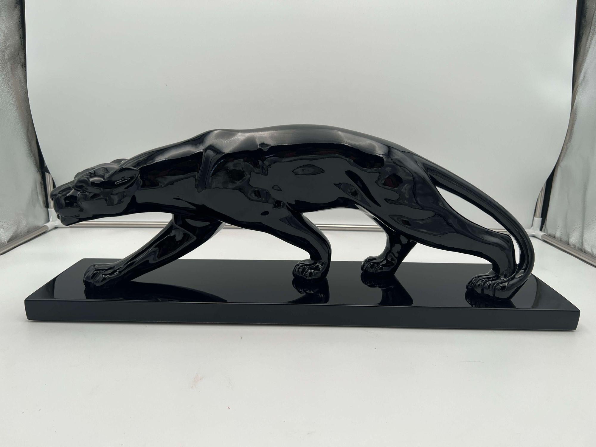 Original Art Deco Panther sculpture from France, Paris around 1930.
 
Model after Salvatore Melani (1902-1934), based on Paul Jouve's panther drawings.
Ceramic mass on rectangular wooden base. Coated with black piano lacquer and polished to high