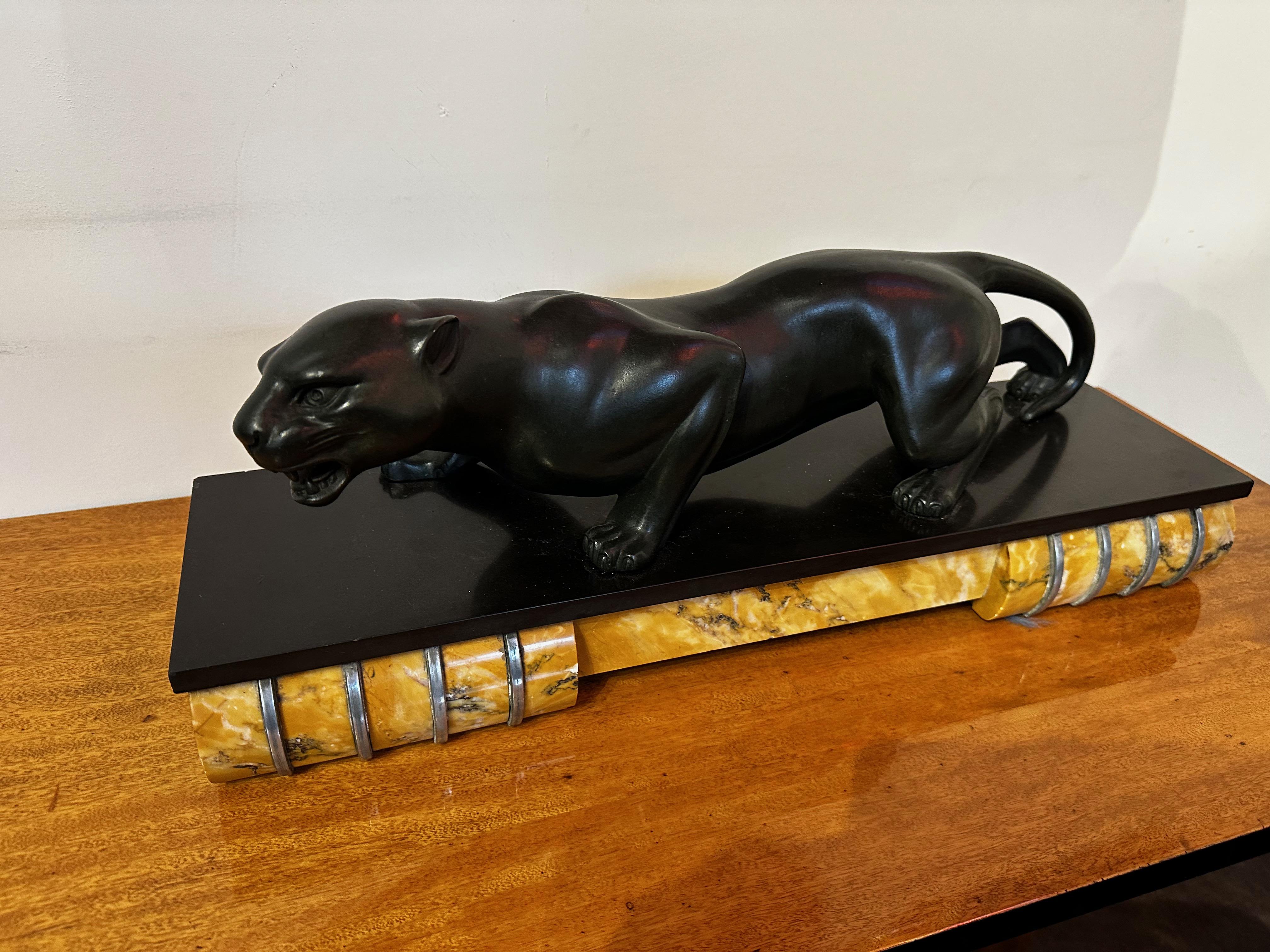 Black Panther Art Deco sculpture was designed and signed by Guy Debe. It features a black metal patinated material of the body of the panther which is a blend of metals called regul based on bronze. The sculptural panther you see resting on top of a