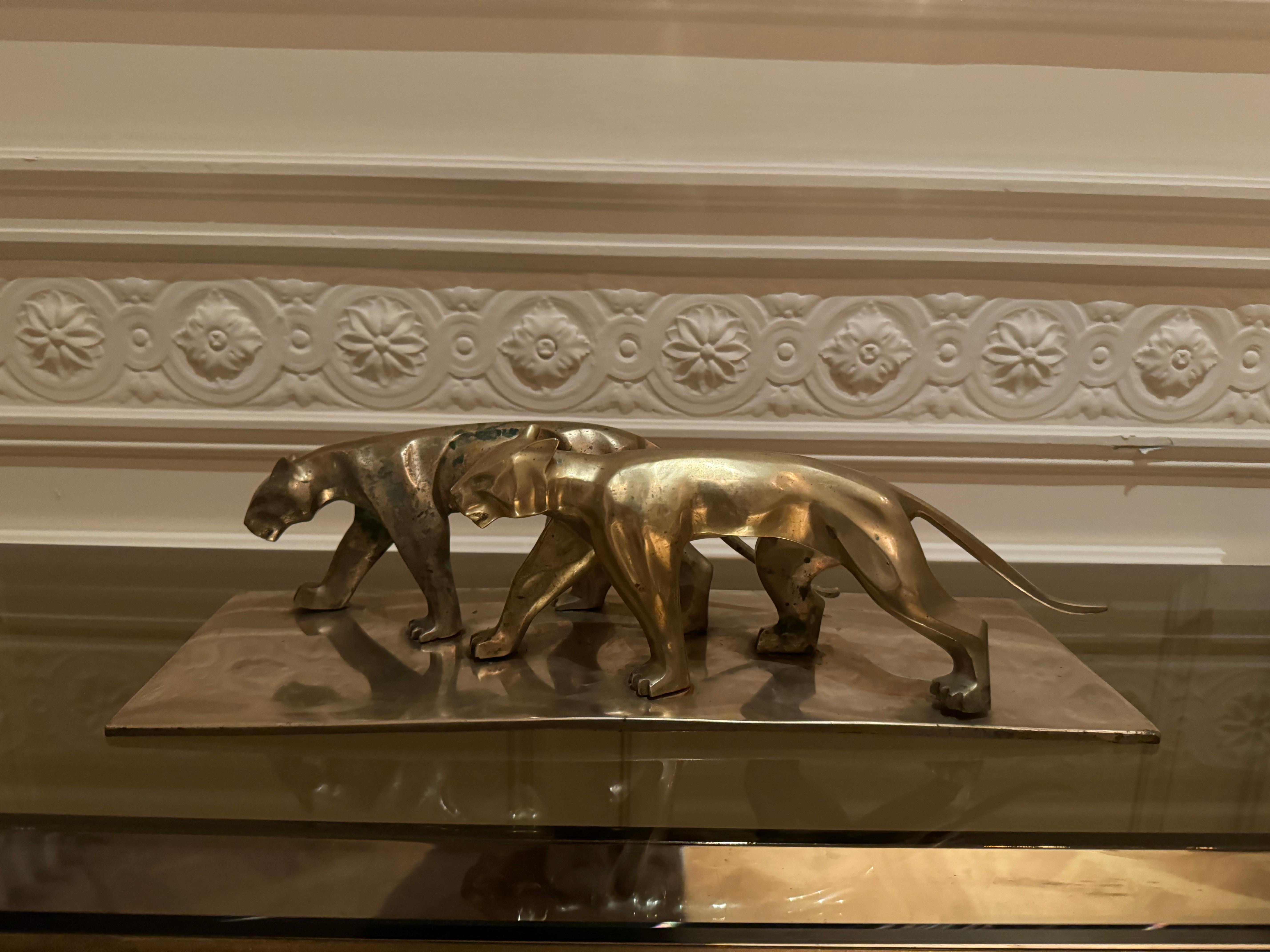 Decorative sculpture of two panters in movements, mounted on a rectangular base. The scultpure is in solid brass, and has a very balanced look. 