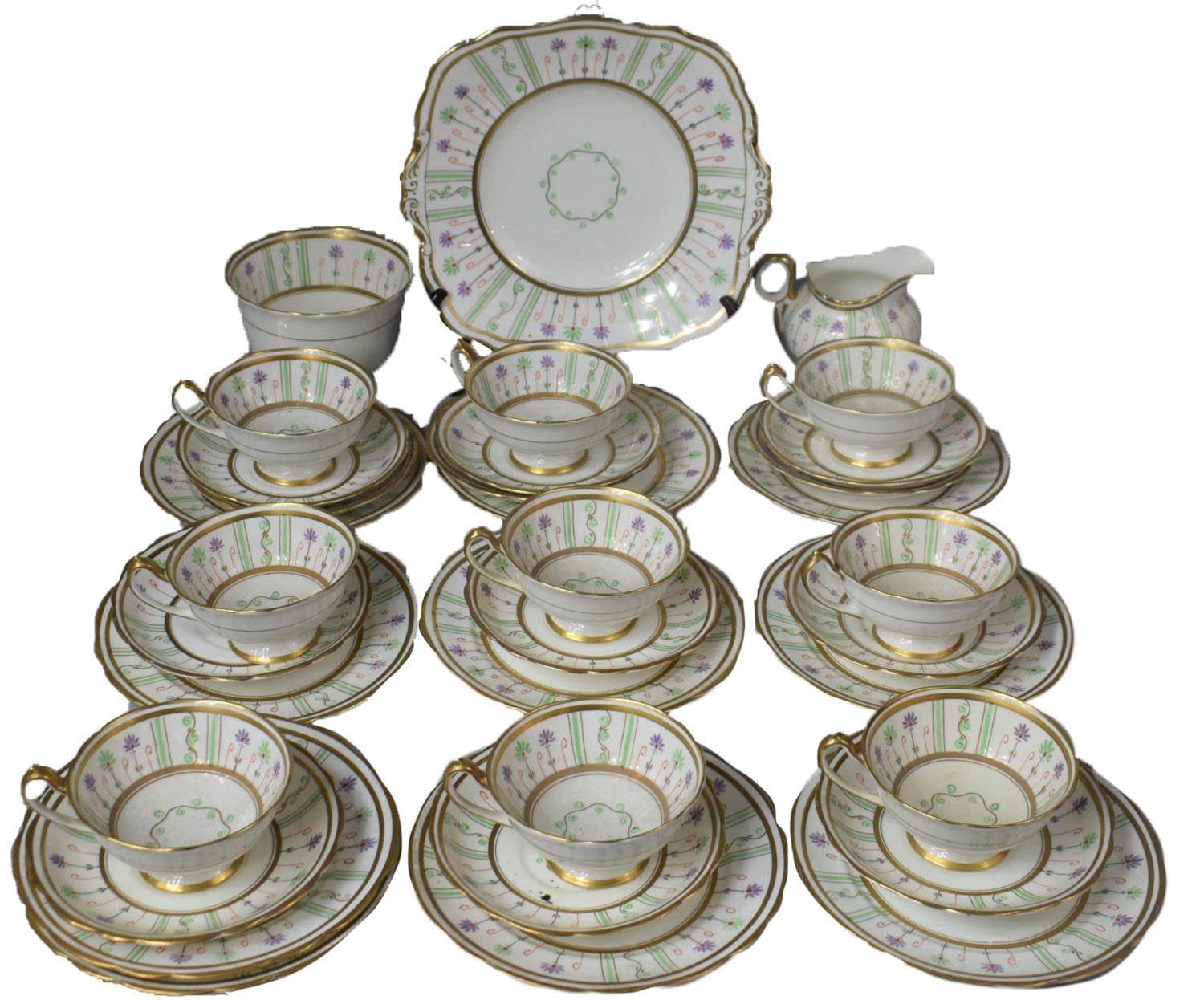 An Art Deco Paragon gilt and polychrome decorated teaservice to comprise 9 cups, 9 saucers, 9 side plates, creamer and a cake plate. Each piece is handpainted in pastel green and purple standing floral design around the insides of each cup and on