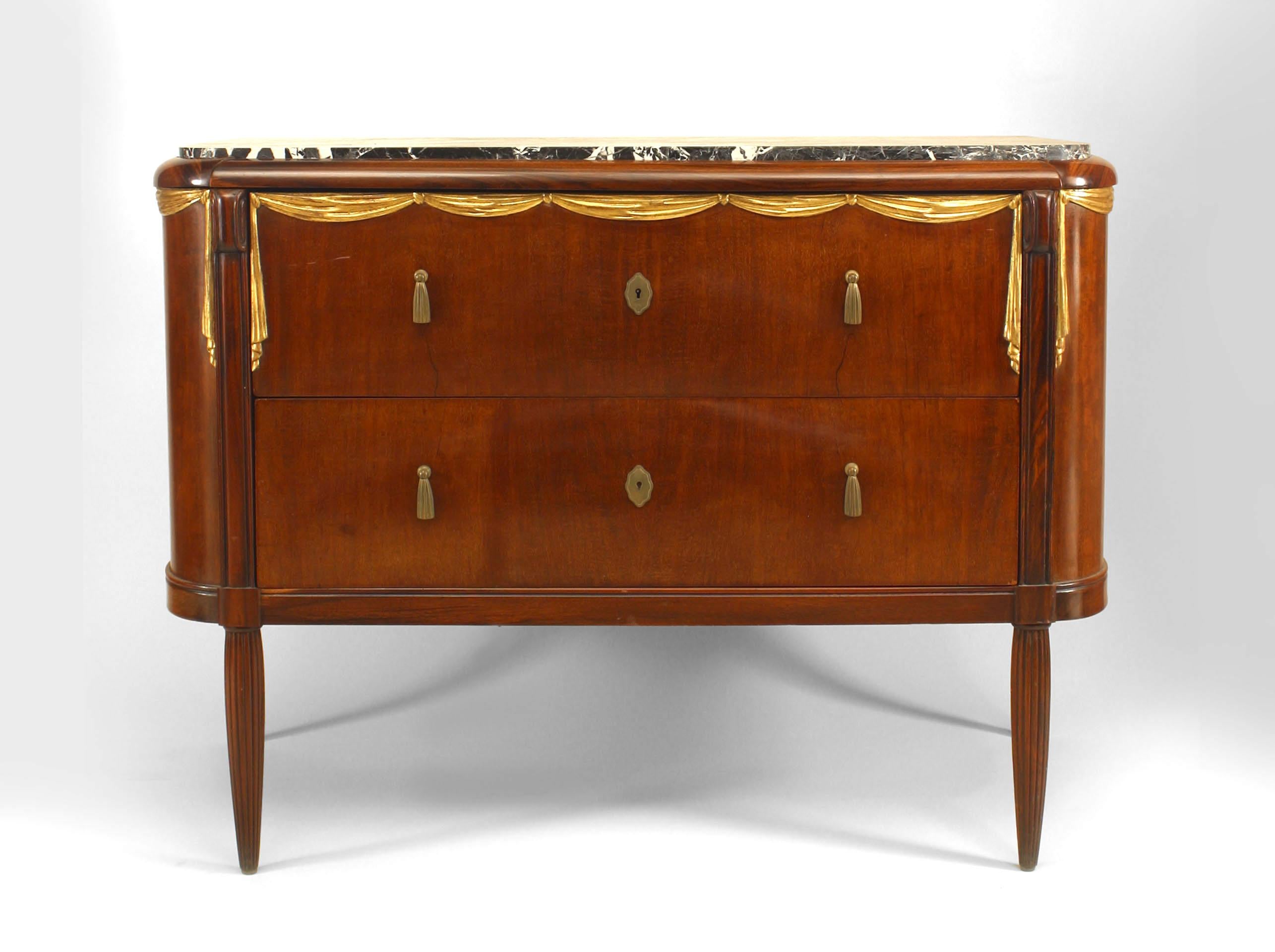 French Art Deco parcel gilt, mahogany & rosewood commode with inset black marble top over a swag carved frieze with 2 long drawers (attributed to MAURICE DUFRENE)
