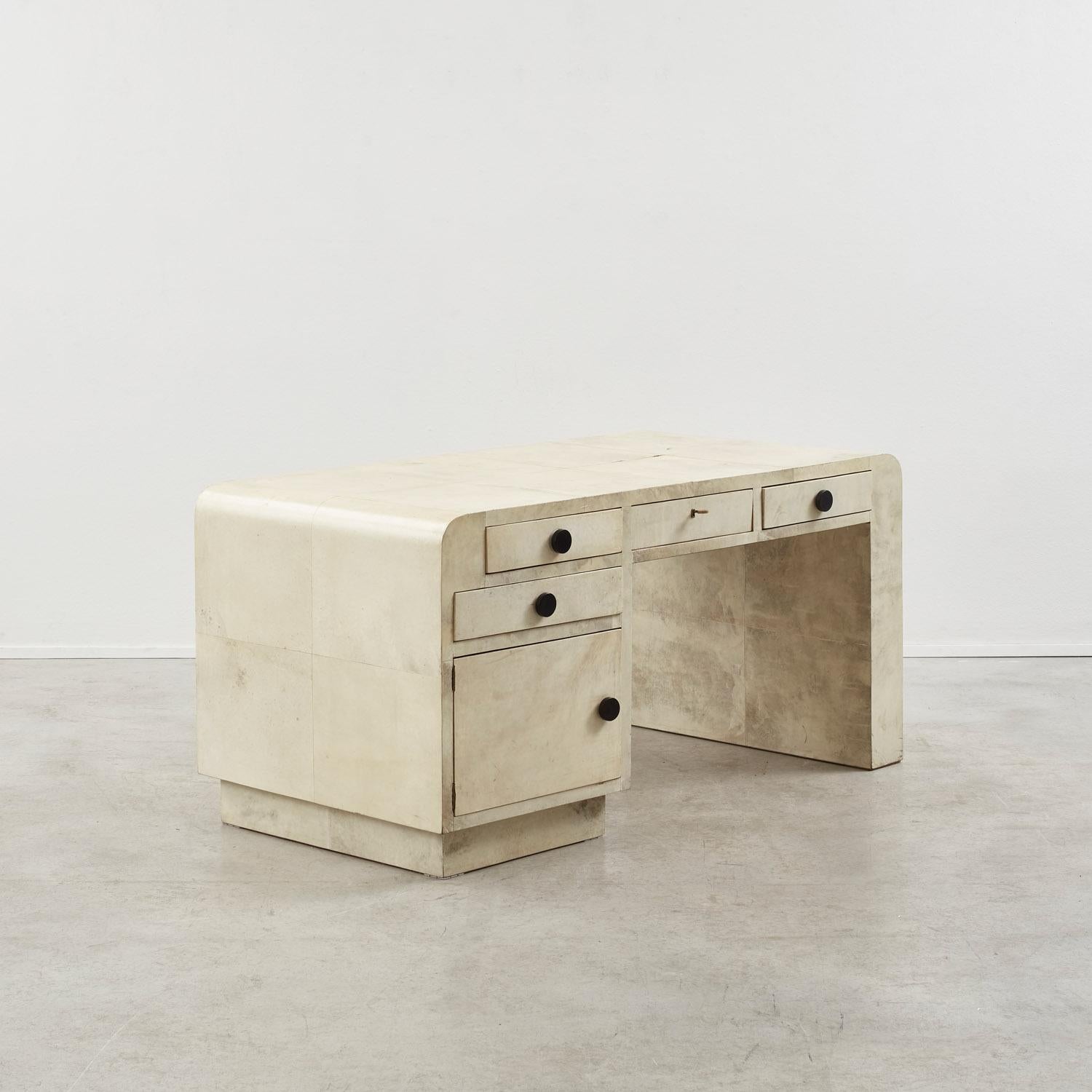 Beautifully tactile, this robust Art Deco desk features unique striations of colour, subtly shifting in shades, according to the parchment’s own patinations. This watercolour like wash is strikingly offset by circular ebonised wood handles. 