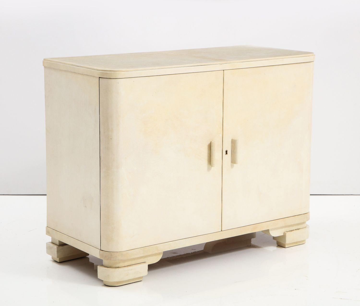 A wonderful Art Deco four drawer chest with rounded front and covered in parchment with fitted interior. Signed N.E. Corengia

