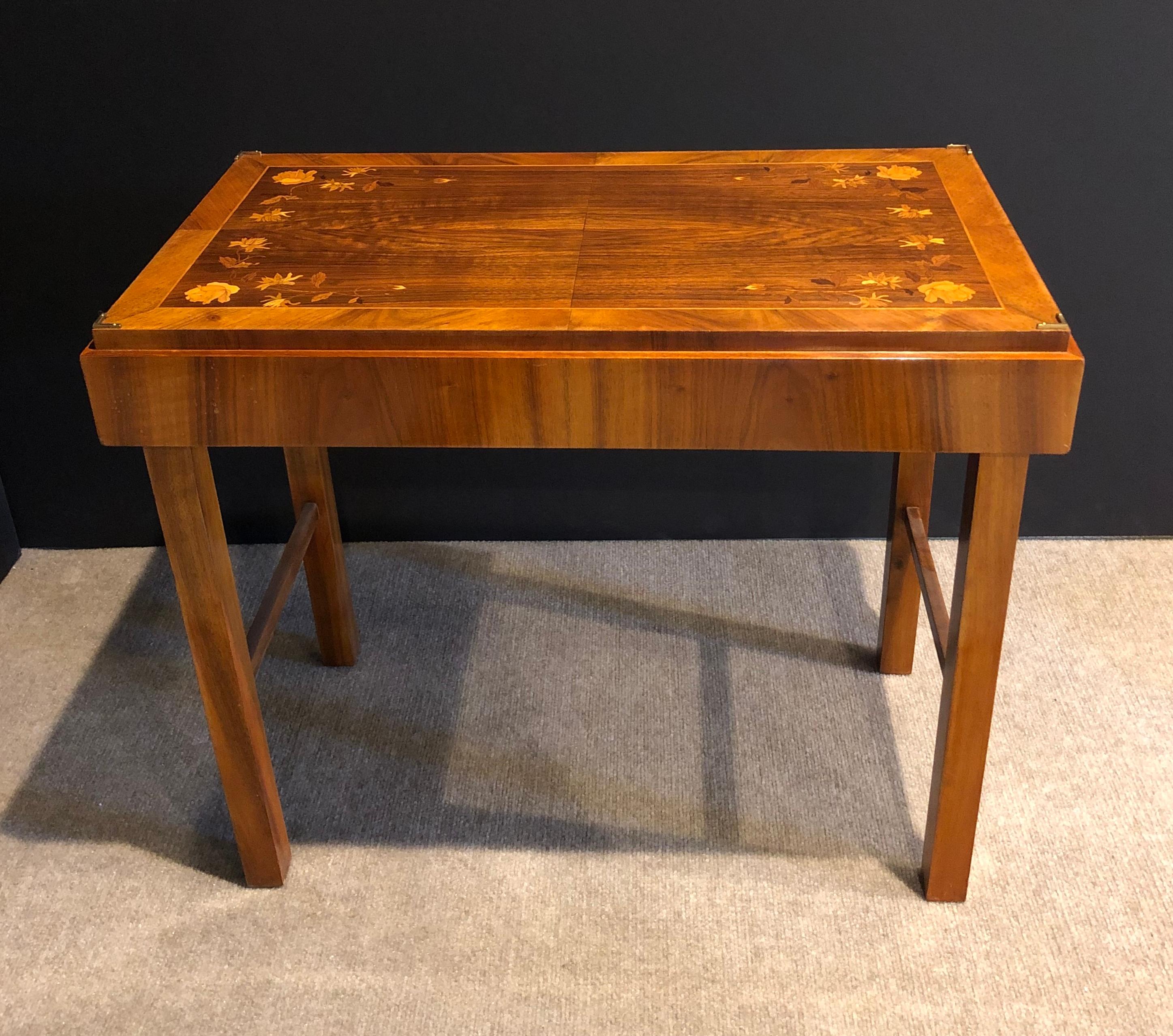 Art Deco walnut and parquetry folding side table. Franz Seifert design for Kunst-Mobel, Germany. Art Deco modern folding snake table with beautiful floral marquetry inlay on top. Makers label on bottom.