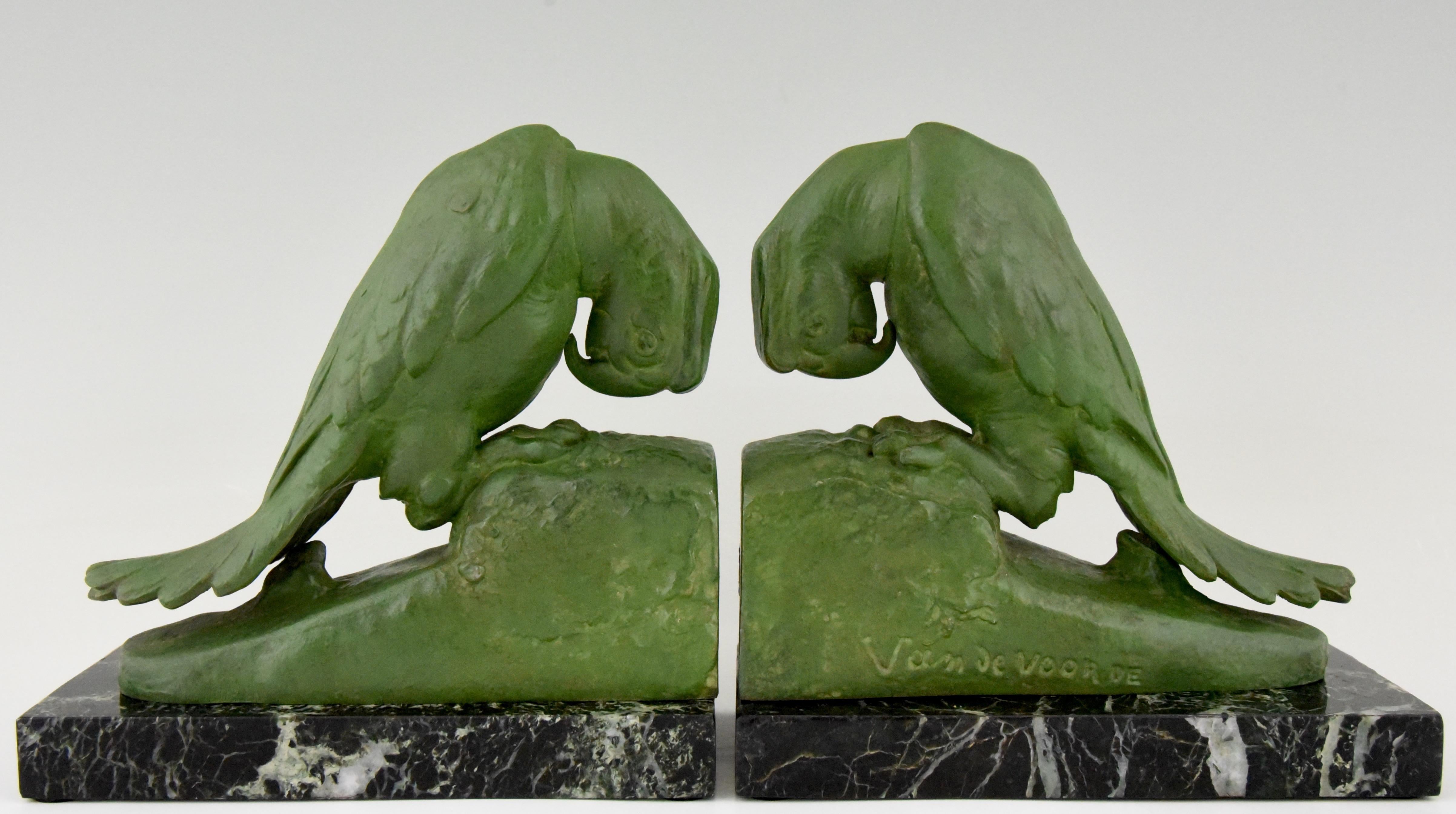 A pair of Art Deco parrot bookends by Georges van de Voorde, Belgian artist who worked in France. Signed and with founders' seal. Lovely green patina, mounted on green marble base, ca. 1925. 

There is a picture of these bookends on page 328 in