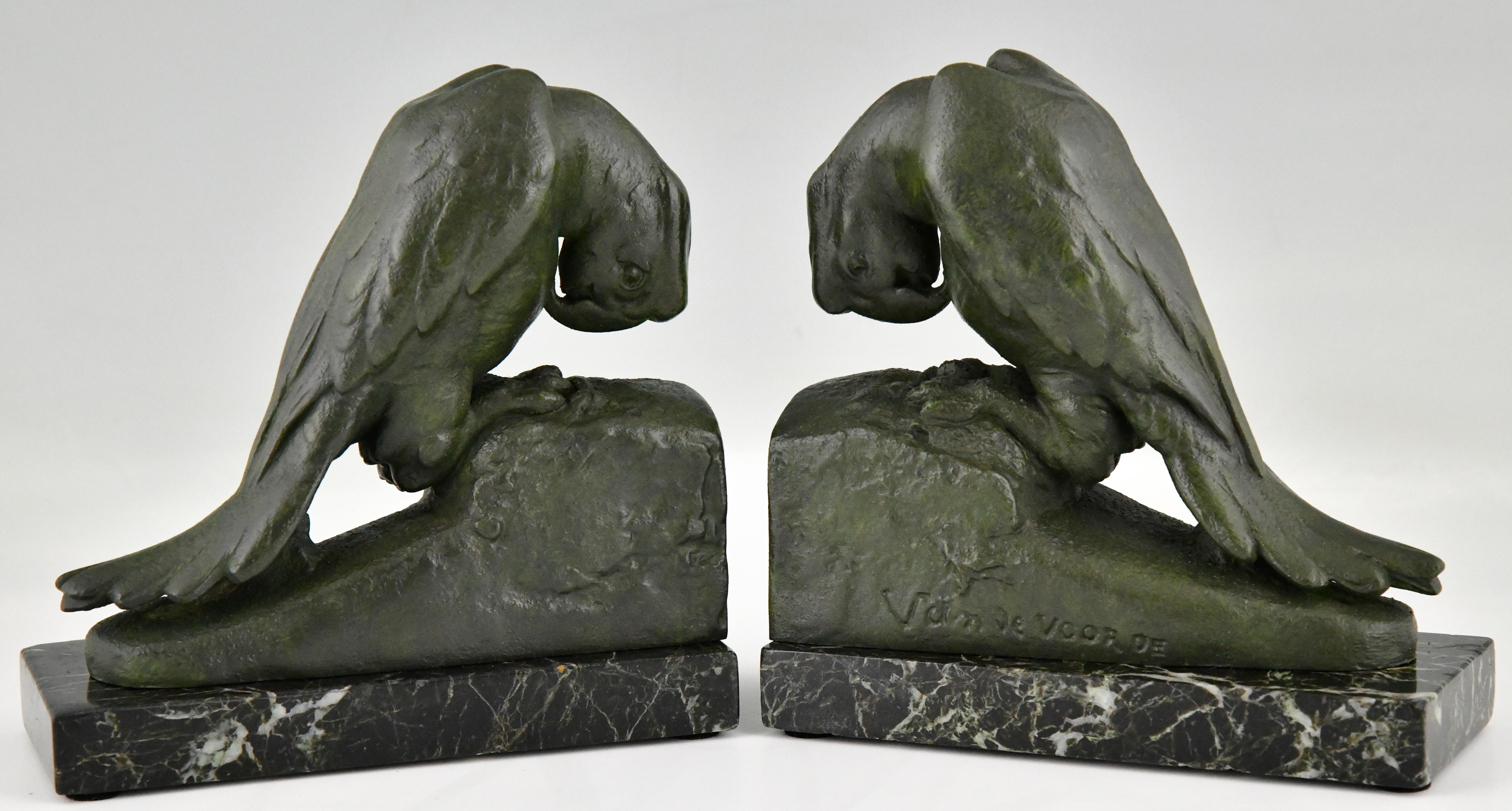 Art Deco parrot bookends by Georges Van de Voorde with Foundry seal Brig, Paris. 
The birds are in patinated Art metal and stand on green marble bases. Ca. 1930. 
Van de Voorde was a Belgian artist born in 1878 who worked in France.
These