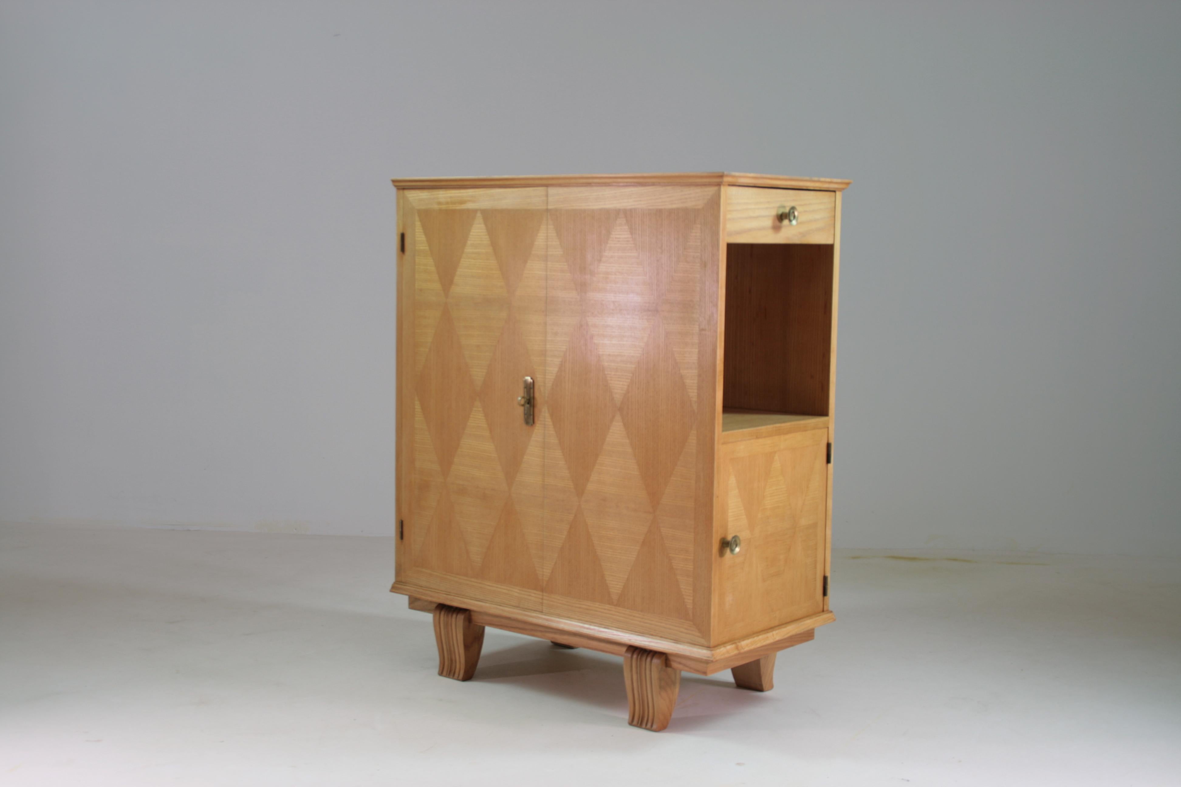Dai un tocco di carattere alla tua casa con questa piccola credenza Art Déco, pratica e raffinata. Progettato per delineare con stile gli spazi, questo pezzo incarna l'eleganza degli anni '50 con i suoi iconici motivi geometrici e le sue linee