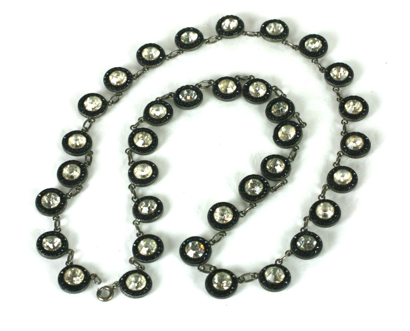 Art Deco Paste Calibre Set Link Chain from the 1920's. Large crystal pastes are set into sterling with molded sapphire glass calibre settings. 
The sapphire glass settings appear dark because they are transparent and set on the dark silver, so the