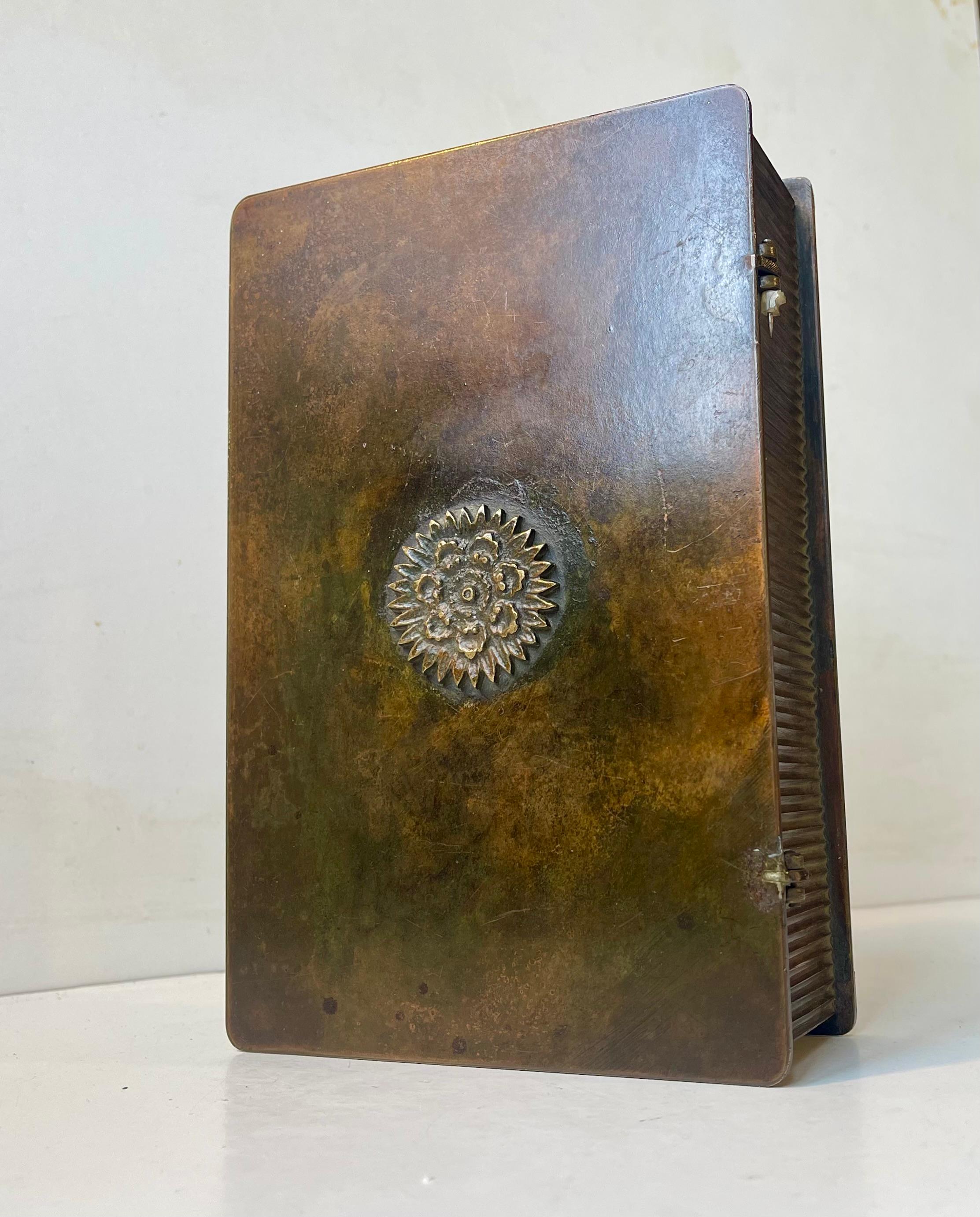 - Heavy Art Deco bronze box with deep vertical ribbings.
 - Clean and strict architectural design. 
- Stylized center-motif of a flower 
- Rich and original patina 
- It was manufactured in Denmark during the 1930s 
- By Tinos in
