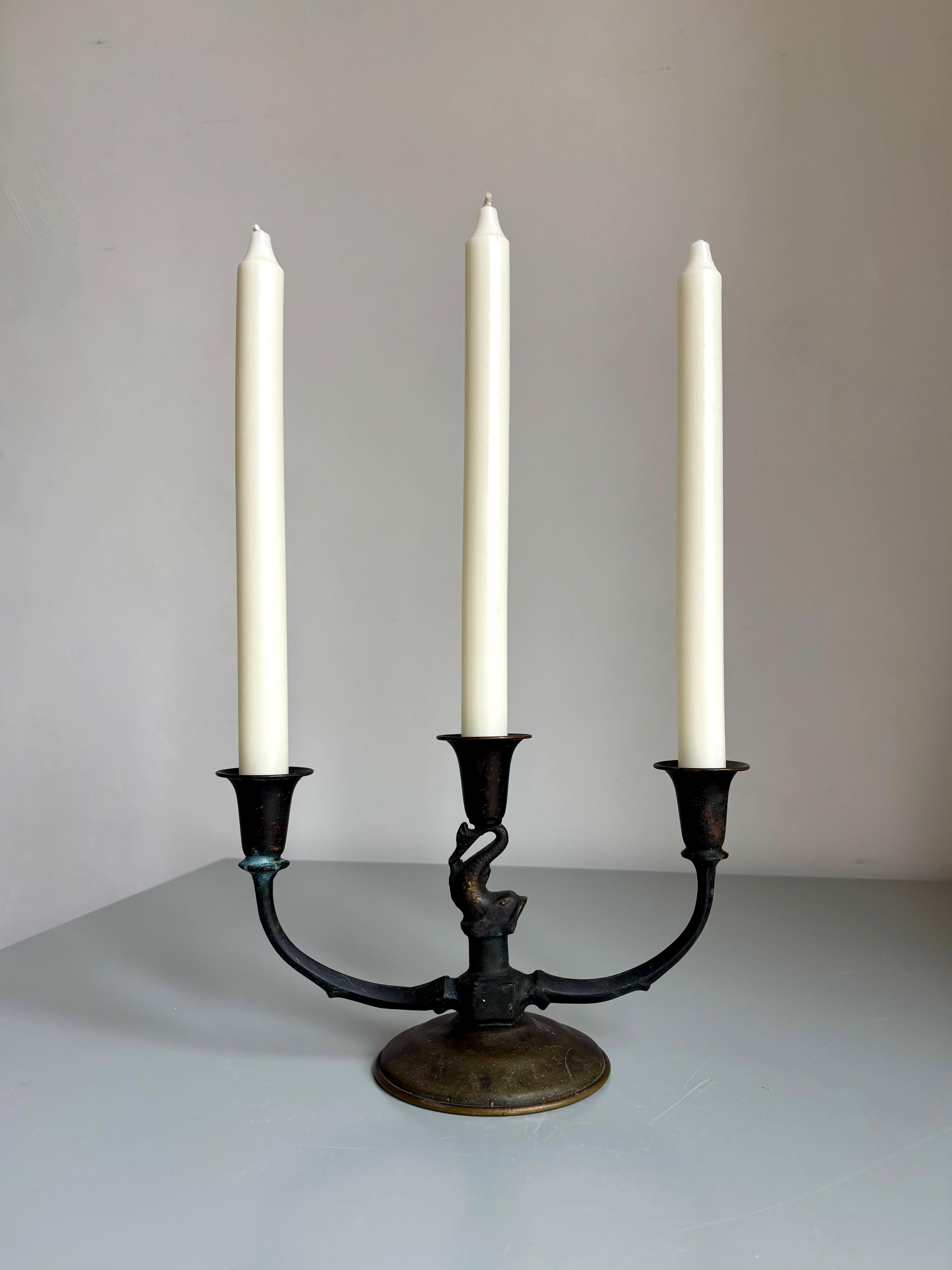Elegant Danish Art Deco solid bronze candelabra handmade circa 1920s. The slender arms extend gracefully from the center that features a beautifully detailed fish. Brown and green patinated appearance that can be polished for a more shiny