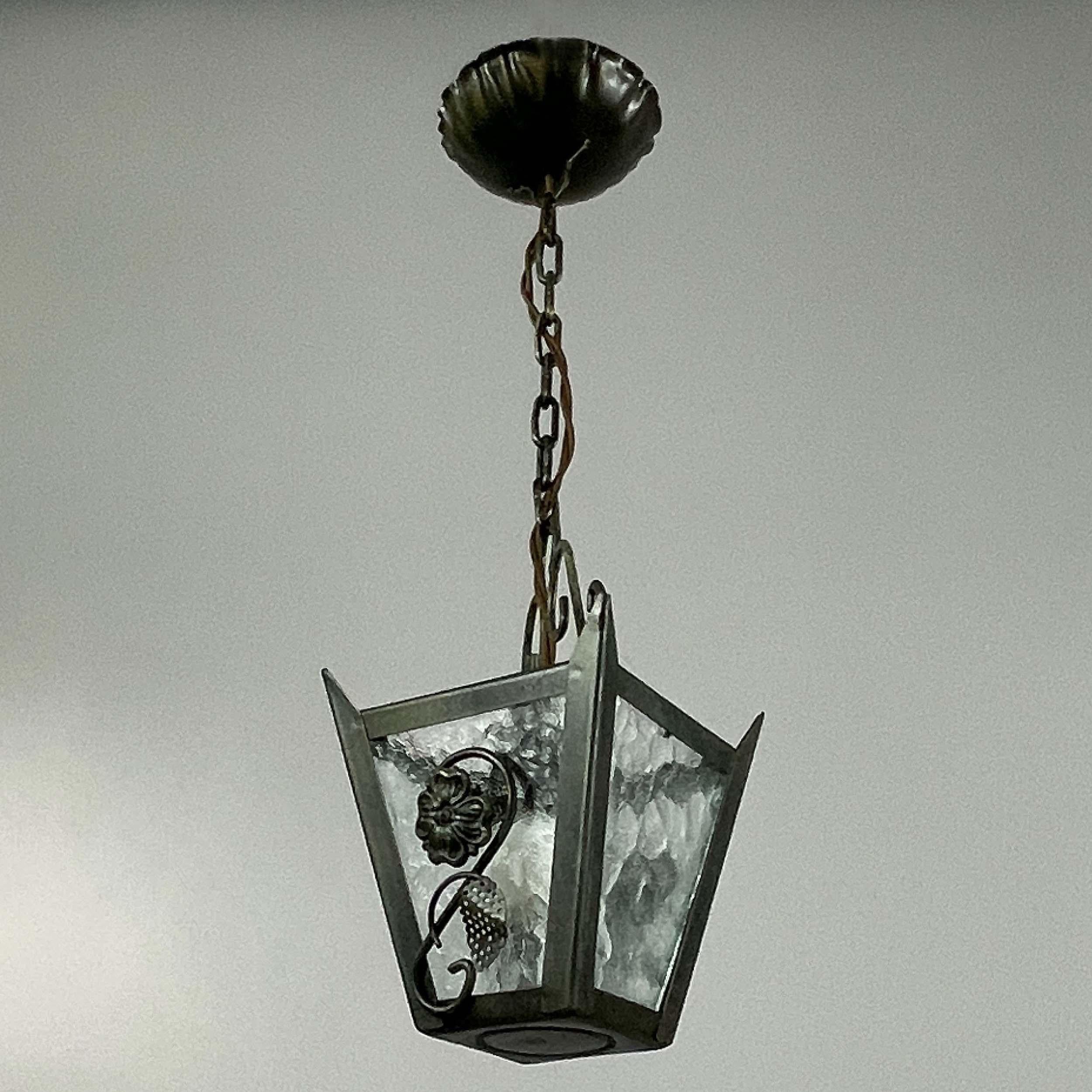 Cette lanterne suédoise de style Art déco (Bjerkås Armatur, style Belysning) a été conçue et fabriquée dans les années 1930-1940).

Le luminaire présente un cadre en fonte patinée, suspendu par une chaîne à un plafond décoratif. 

Elle est ornée de