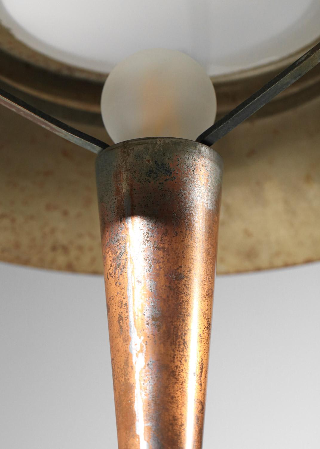 Lampe de table Art déco des années 1950. Structure et abat-jour en métal patiné avec un disque en verre dépoli blanc. Très bel état vintage, avec des traces d'oxydation sur l'ensemble de la lampe et principalement sur le pied (voir photos). Système
