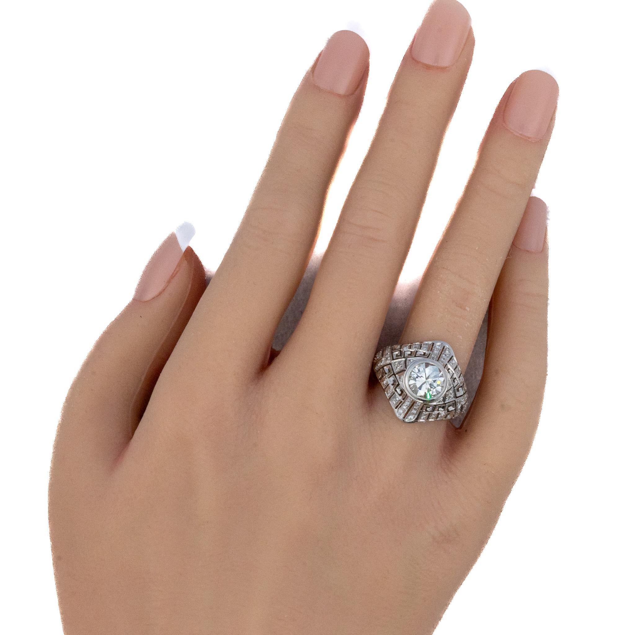 Art Deco Pave and Brilliant Cut Diamond Ring

Description: This 18K white gold ring features a striking diamond centerpiece framed within an architectural panel design inspired by geometric Deco motifs. The bold, squared silhouette softens into