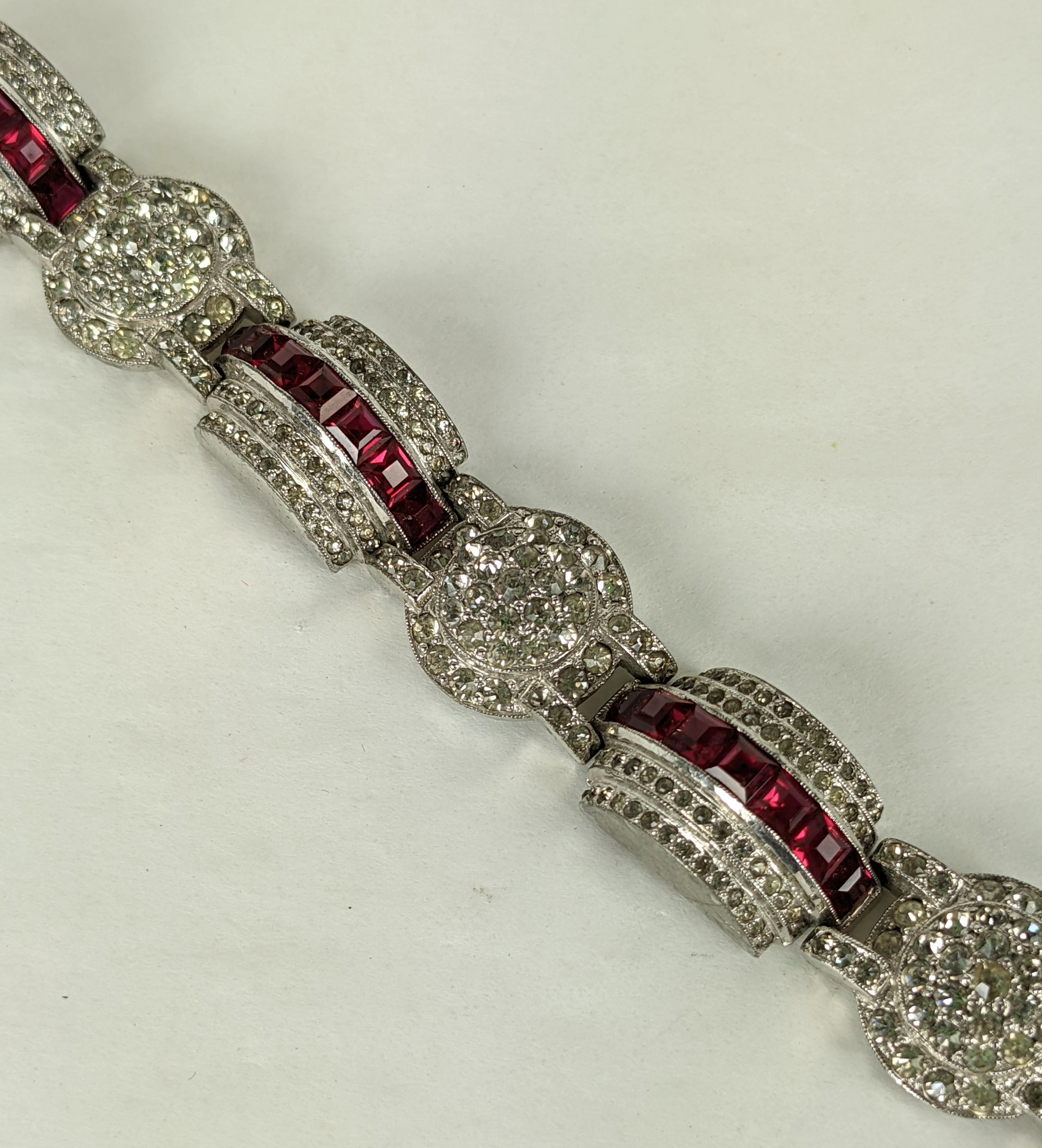Wonderful Art Deco Pave and Channel Set Ruby Bracelet from the 1930's. Stepped and circular links are pave set with rhinestone crystals and  square cut ruby pastes are set across the top of the domed motifs. Elegant and dimensional. 1930's USA.   7