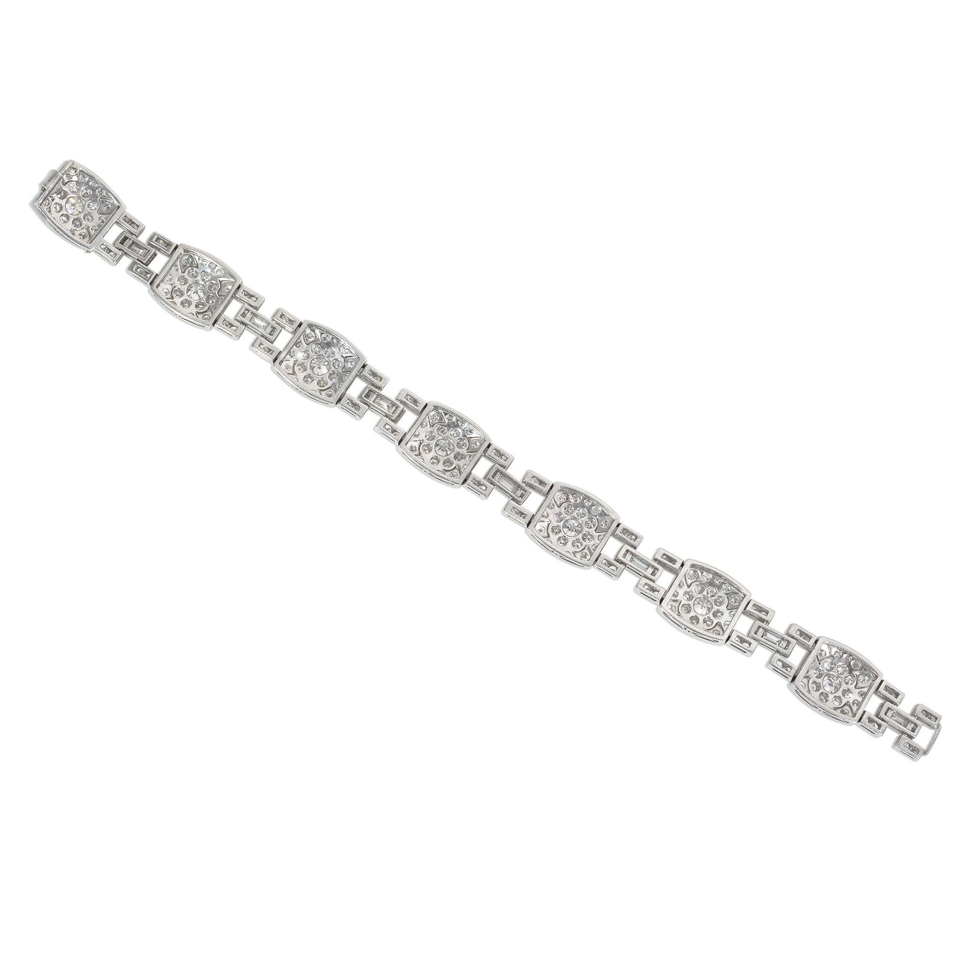 An Art Deco diamond and platinum plaque bracelet featuring rounded rectangular pavé diamond panels with stylized diamond flowers, joined by rectangular links centered by baguette-cut diamonds, in platinum.  Atw 6.67 cts.

* Includes letter of