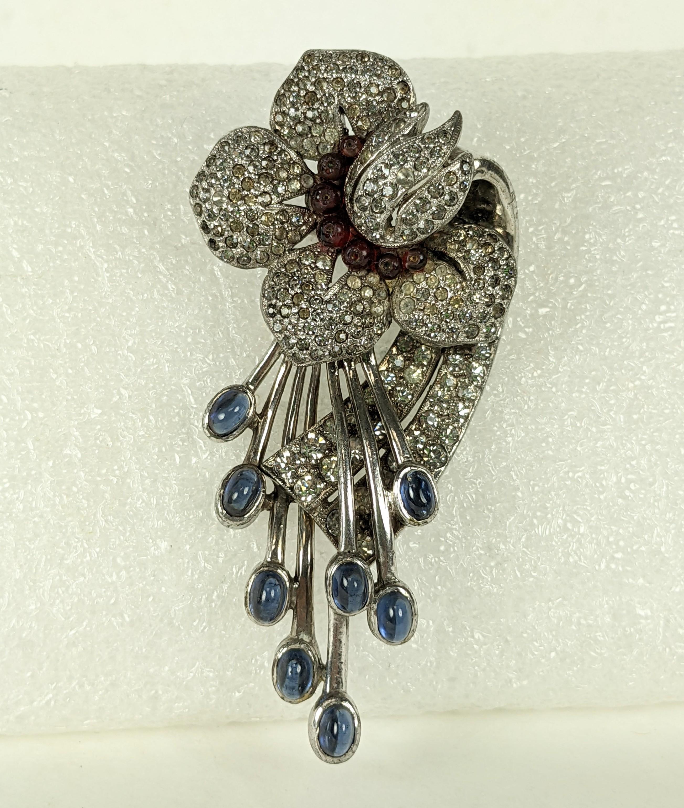 Attractive Art Deco Pave Lily Brooch of high quality from the 1930's. Designed as a spitting lily with cabs of faux sapphires from ruby bead center. Fine pave work throughout flower head and spray.
1930's USA likely made by DeRosa.  3.25