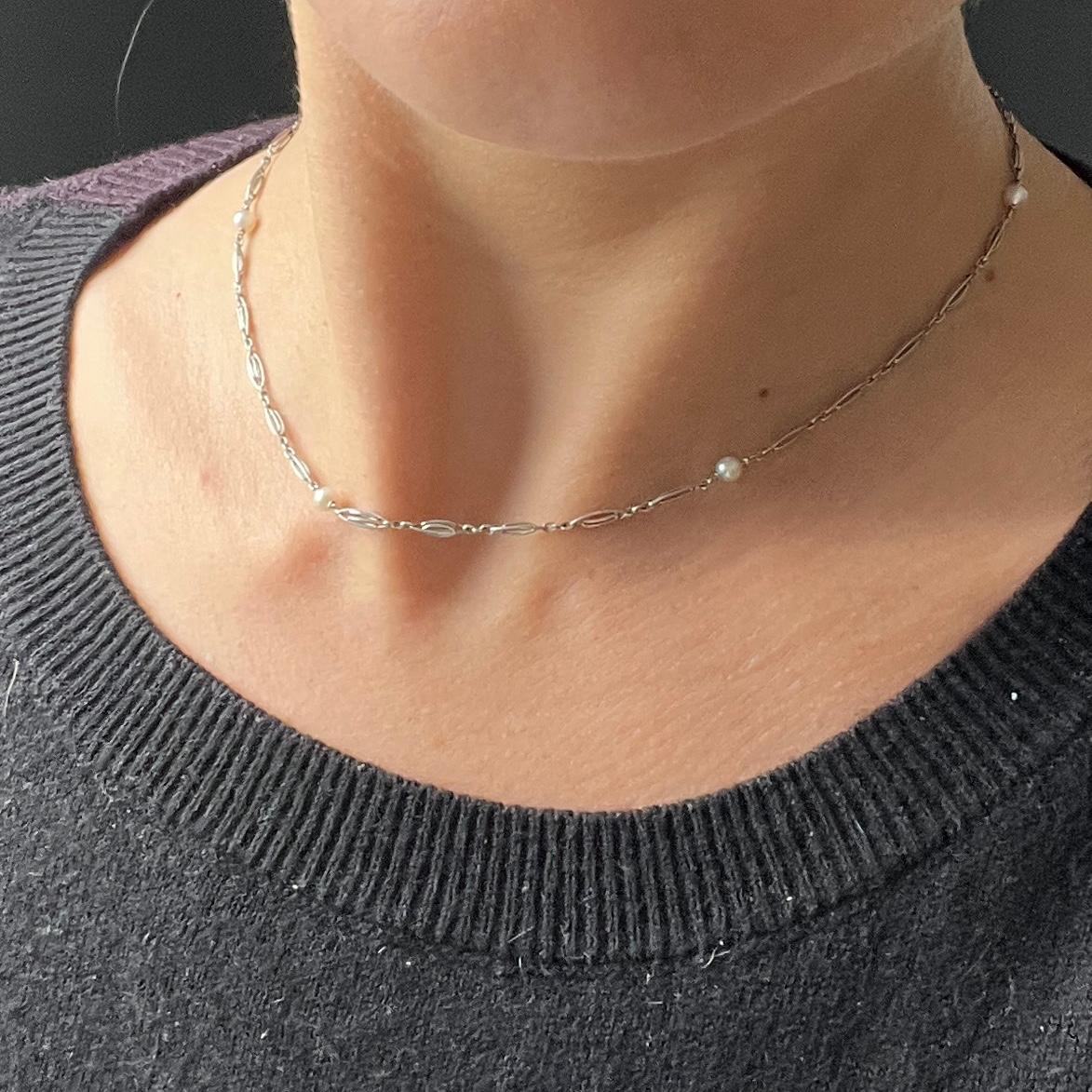 Ce collier très délicat est composé d'une chaîne en platine fine et détaillée et d'une seule pièce de monnaie.  perles. 

Longueur : 37 cm
Diamètre de la perle : 4 mm

Poids : 4.8 g