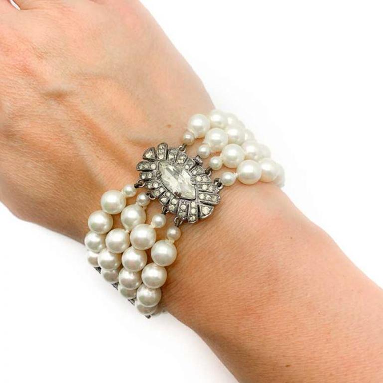 A truly beautiful original Art Deco Pearl Silver and Paste Bracelet dating to around the 1930s. Featuring an art deco design solid sterling silver clasp set with paste stones fastening a quadruple row of lustrous glass faux pearls. Especially love