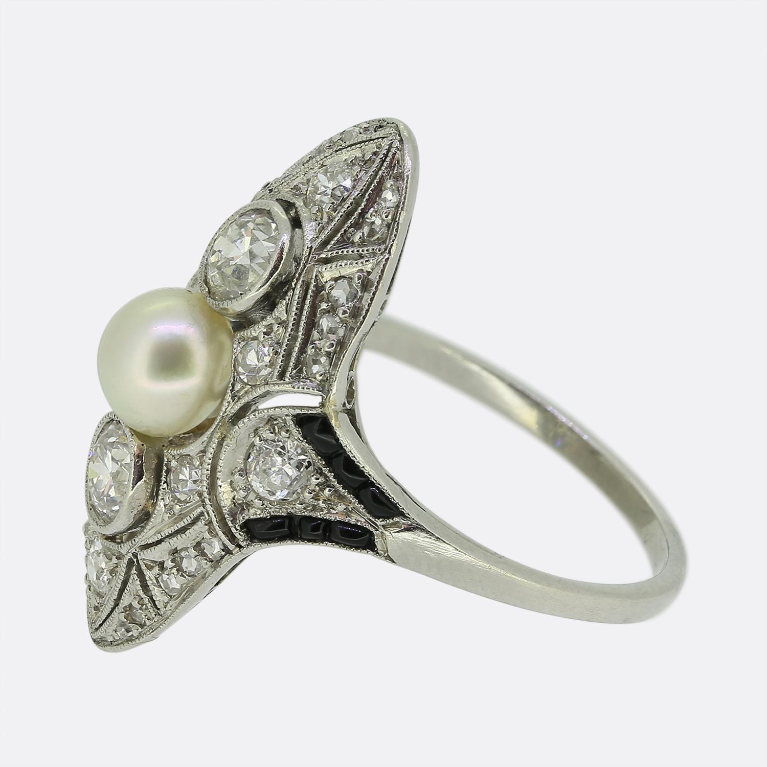 This is a wonderful diamond tablet ring that dates back to the Art Deco era. The ring features a central natural pearl with an old European cut diamond set both above and below. Surrounding the centre stones there is fine pierced work featuring both