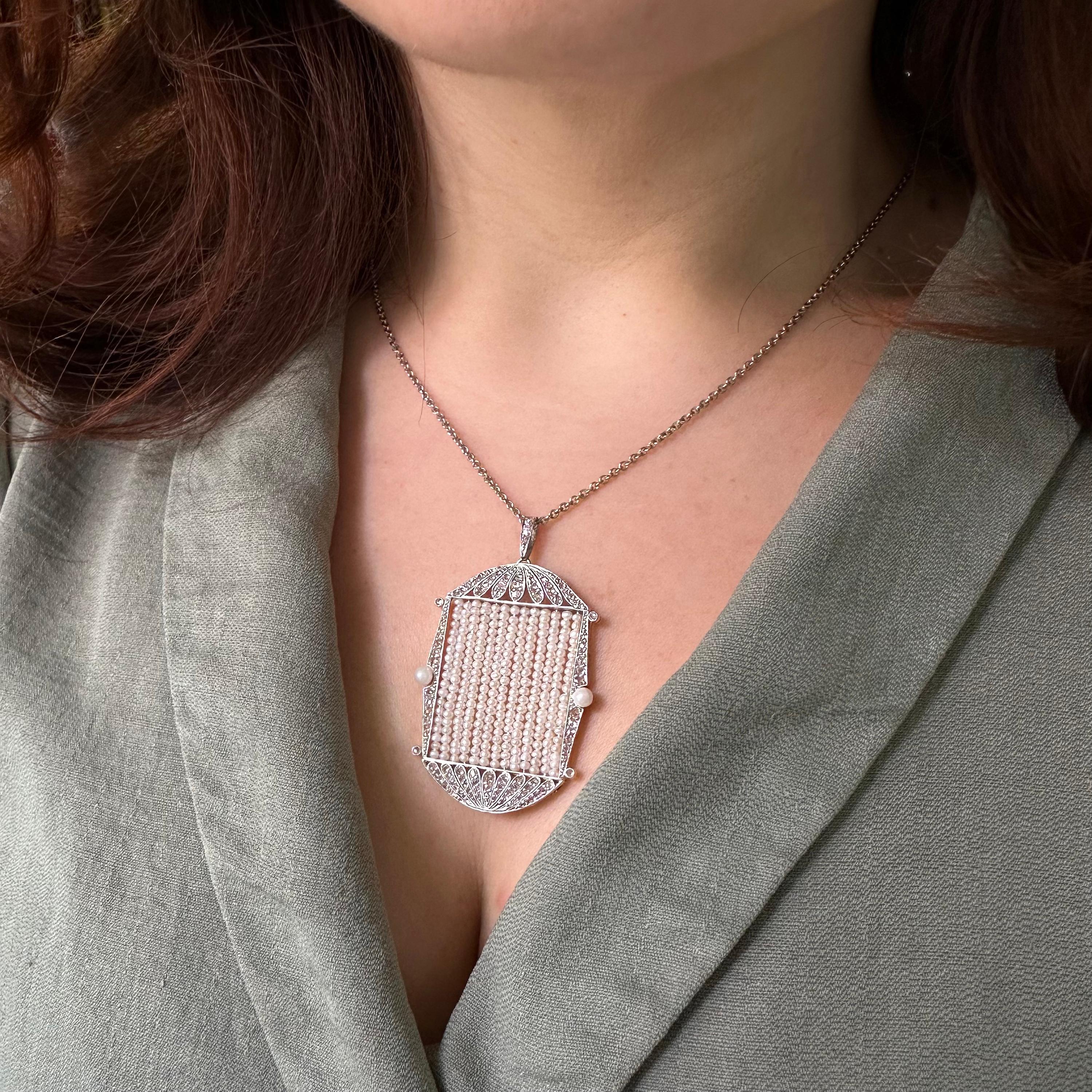 Pendente con perle e diamanti in stile Art Déco, con al centro file di perle coltivate o naturali aggiunte di recente, circondate da una cornice di diamanti taglio rosa, con una perla naturale su ciascun lato, con cappuccio e base scanalati a forma