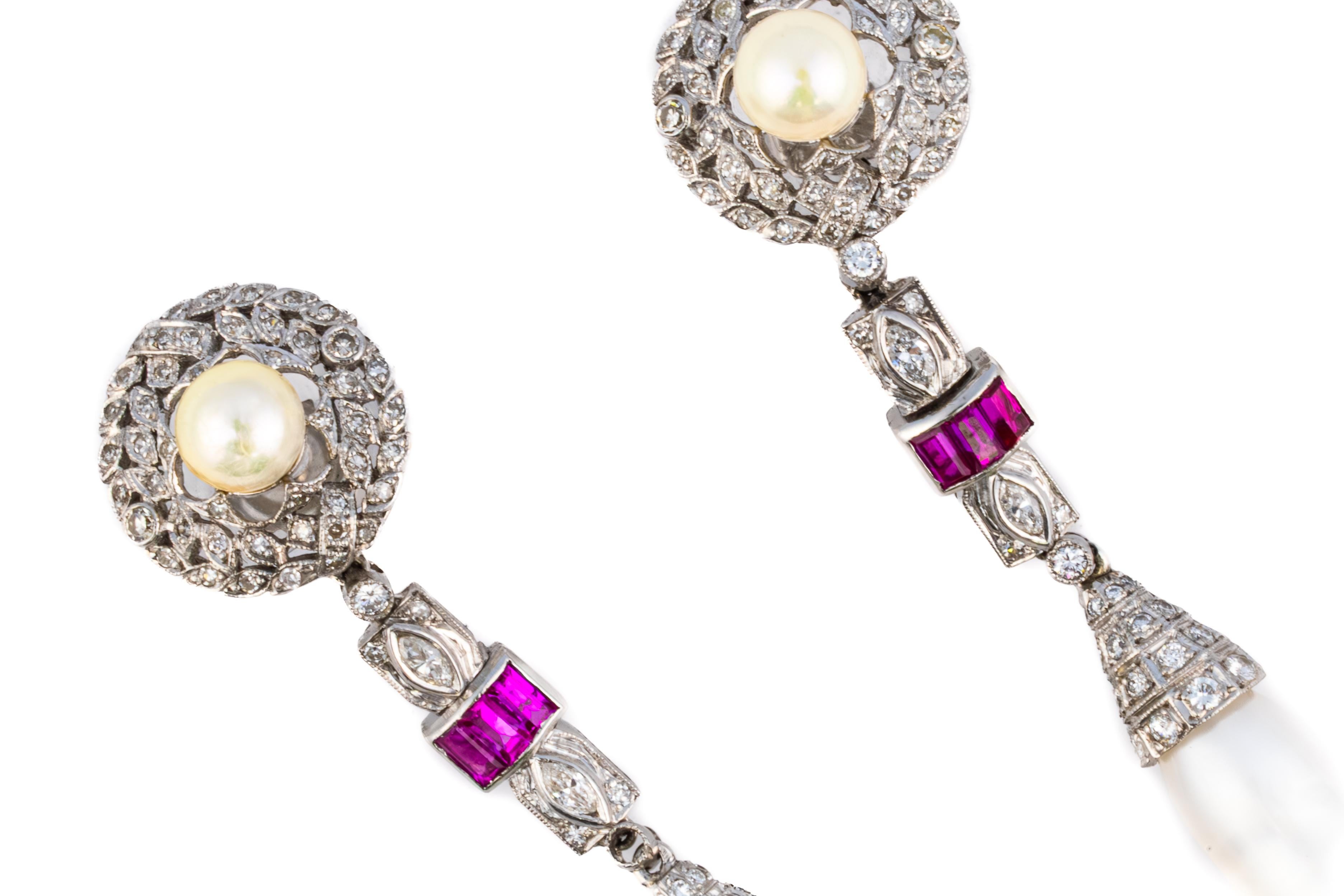Art Deco Pearl, Ruby, and Diamond Drop Earrings

Description:
A refined pair of Art Deco drop earrings featuring round and elongated natural pearls accented by vibrant rubies and shimmering diamonds. The design begins with a bezel-set pearl